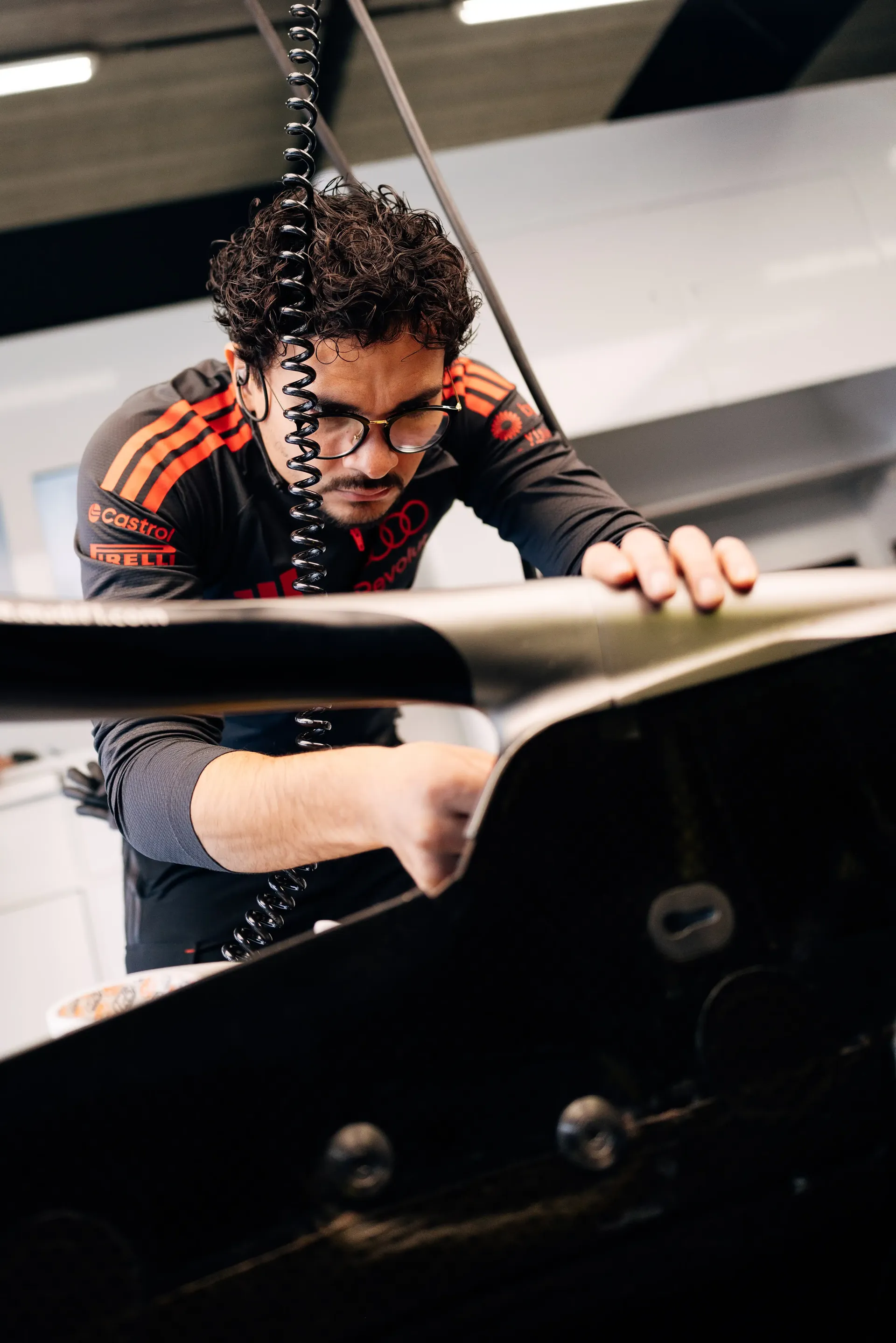 Audi Revolut F1® Team mechanic inspects the Formula 1® car during preparations inside the Audi Revolut F1® Team garage.