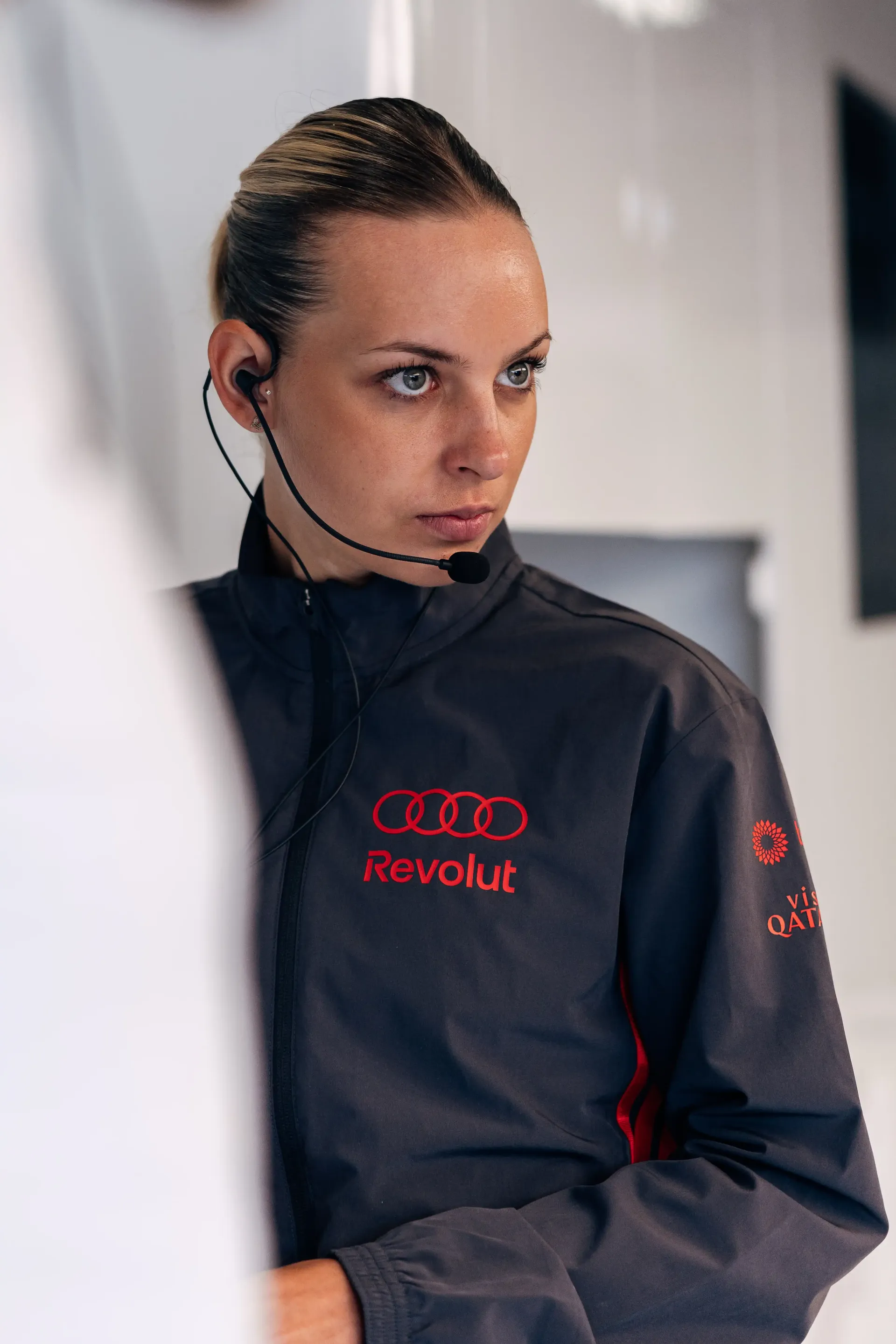 Audi Revolut F1® Team mechanic wearing a headset focuses on garage operations during the Formula 1® Belgian Grand Prix weekend.