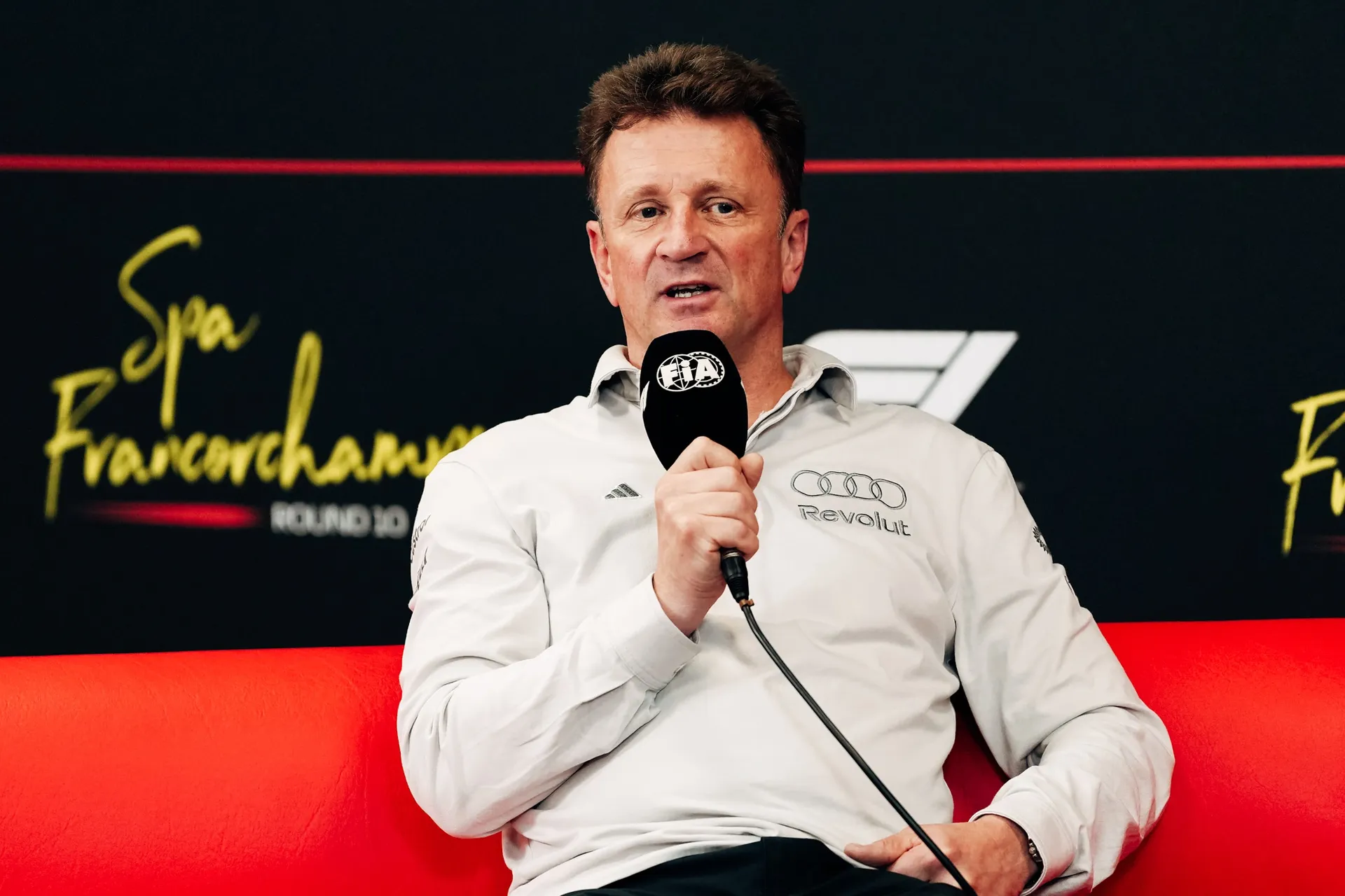 Allan McNish racing director at the Audi Revolut F1® Team giving an interview inside the FIA paddock