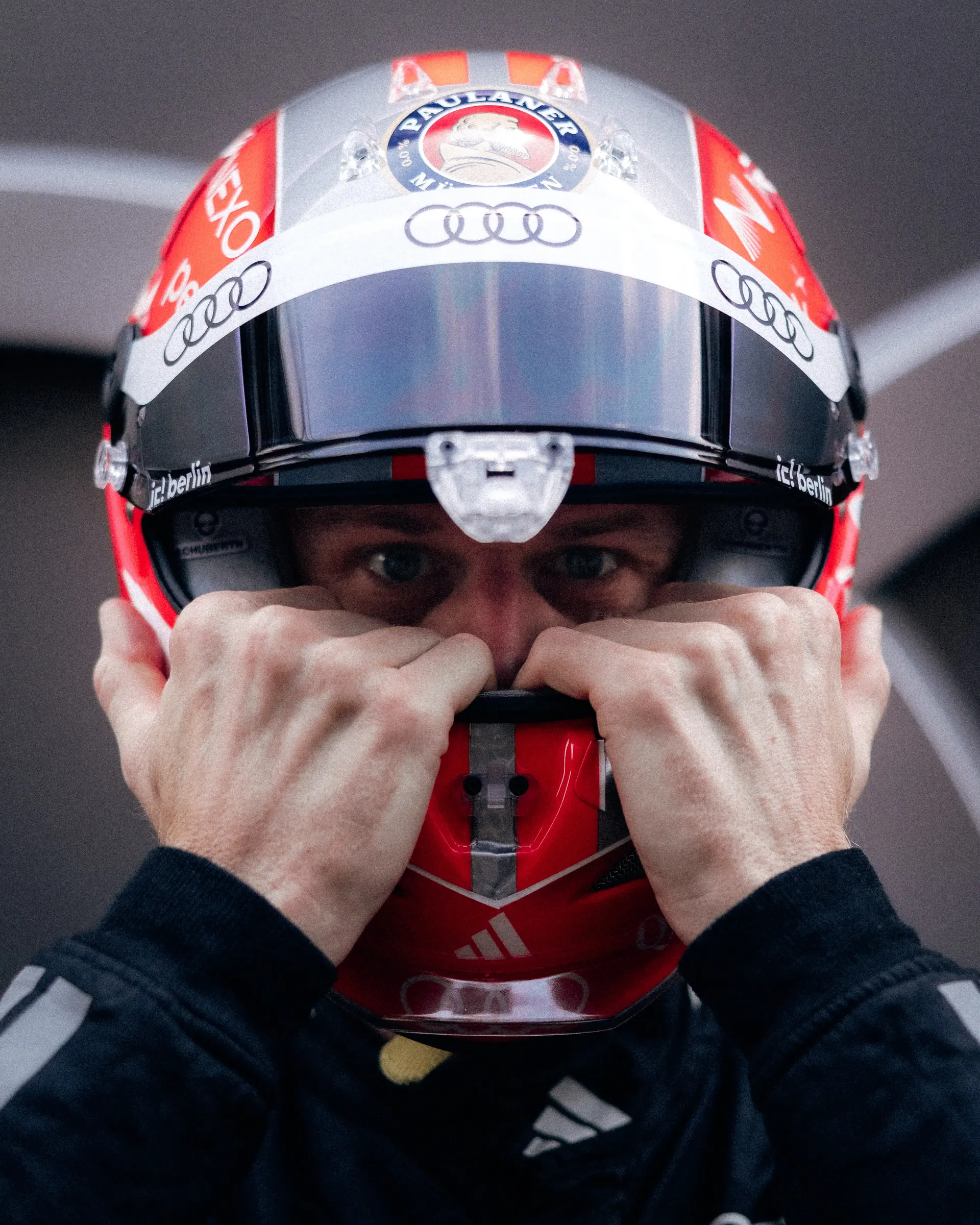 Close-up of Nico Hulkenberg adjusting the chin strap of his special Belgian Grand Prix helmet at the Audi Revolut F1® Team garage.