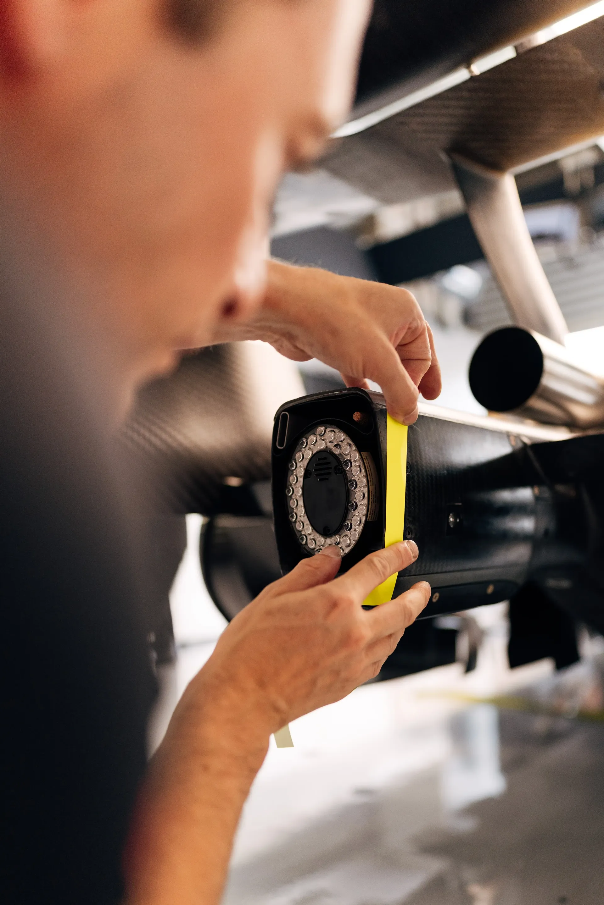 Audi Revolut F1® Team mechanic inspecting a Formula 1® car component during garage preparations for the Belgian Grand Prix.