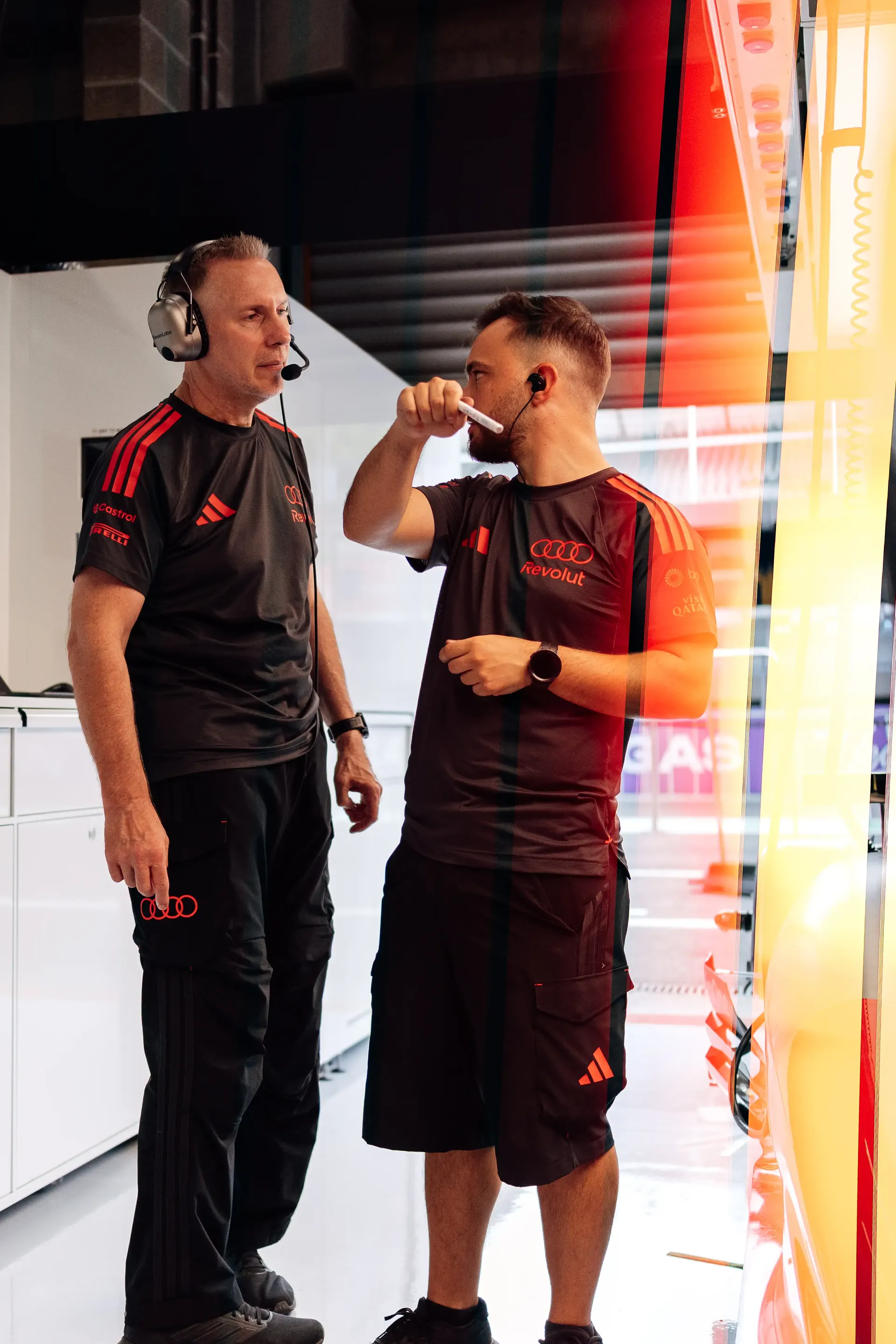 Two Audi Revolut F1® Team mechanics discussing preparations inside the garage ahead of the Belgian Grand Prix at Spa-Francorchamps on Thursday.