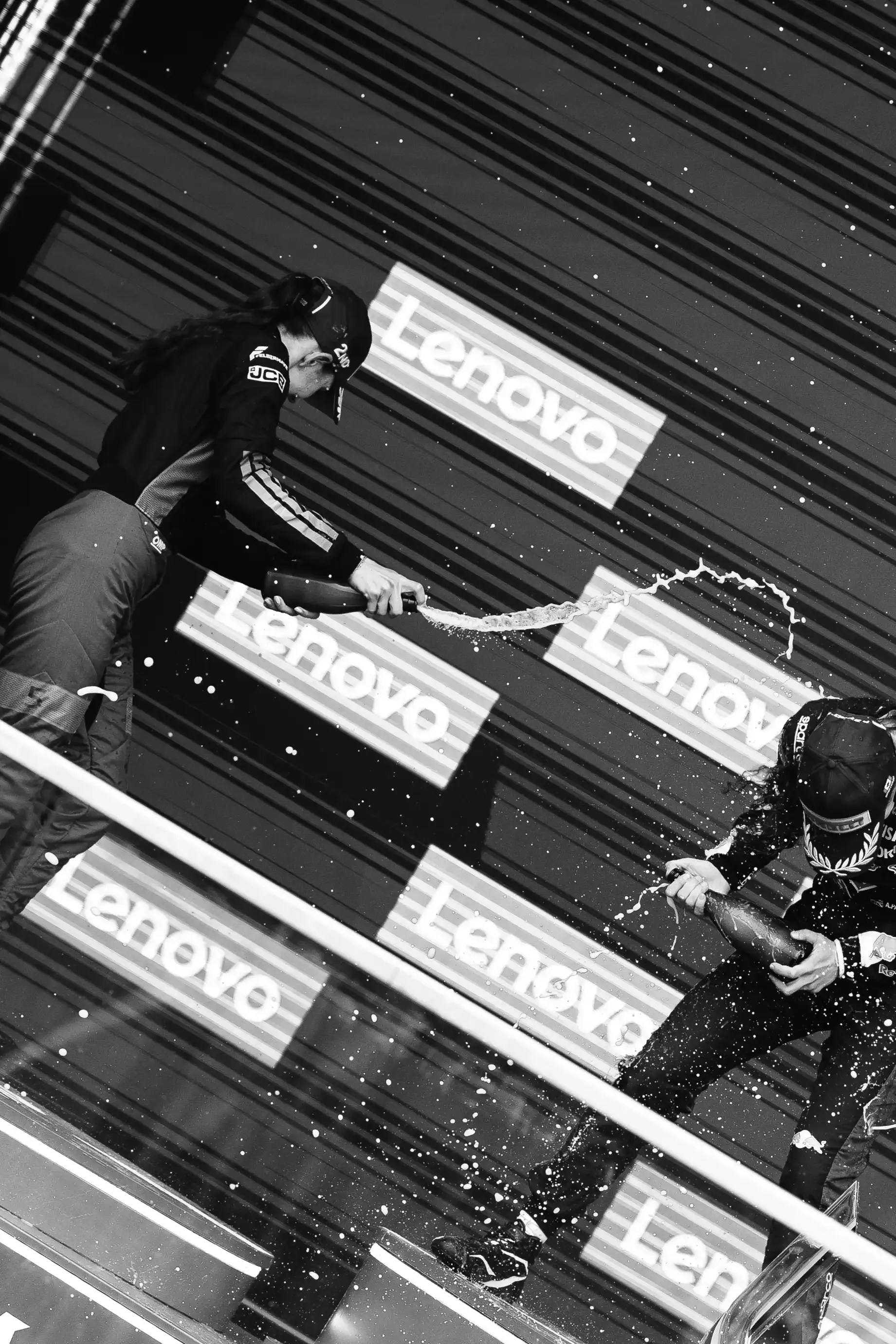 Black and white shot of Emma Felbermayr driver at the Audi Revolut F1® Team Academy cheering and spraying champagner on the podium P2 at the Canada Grand Prix 2026 on racing day