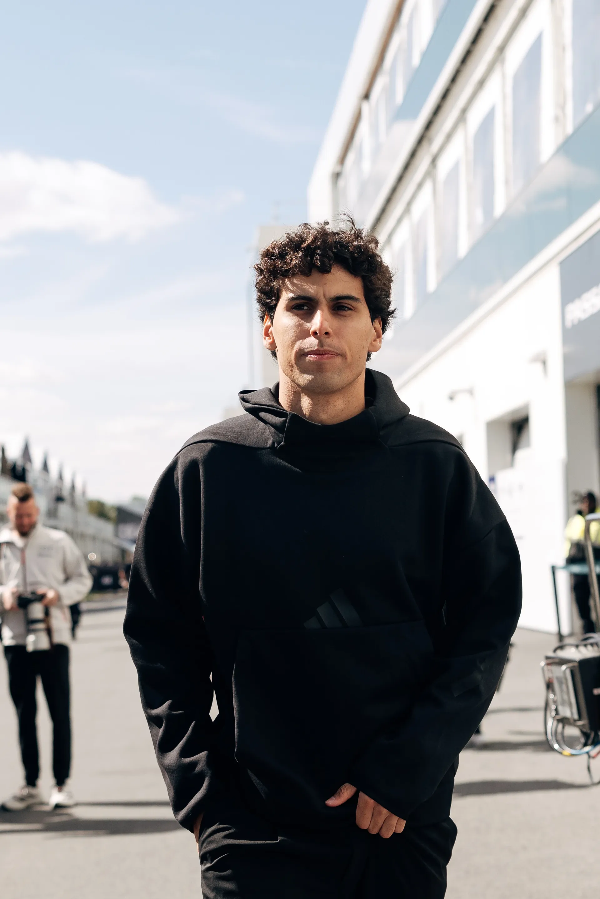 Gabriel Bortoleto walking through the paddock in black Audi Revolut F1® Team hoodie.