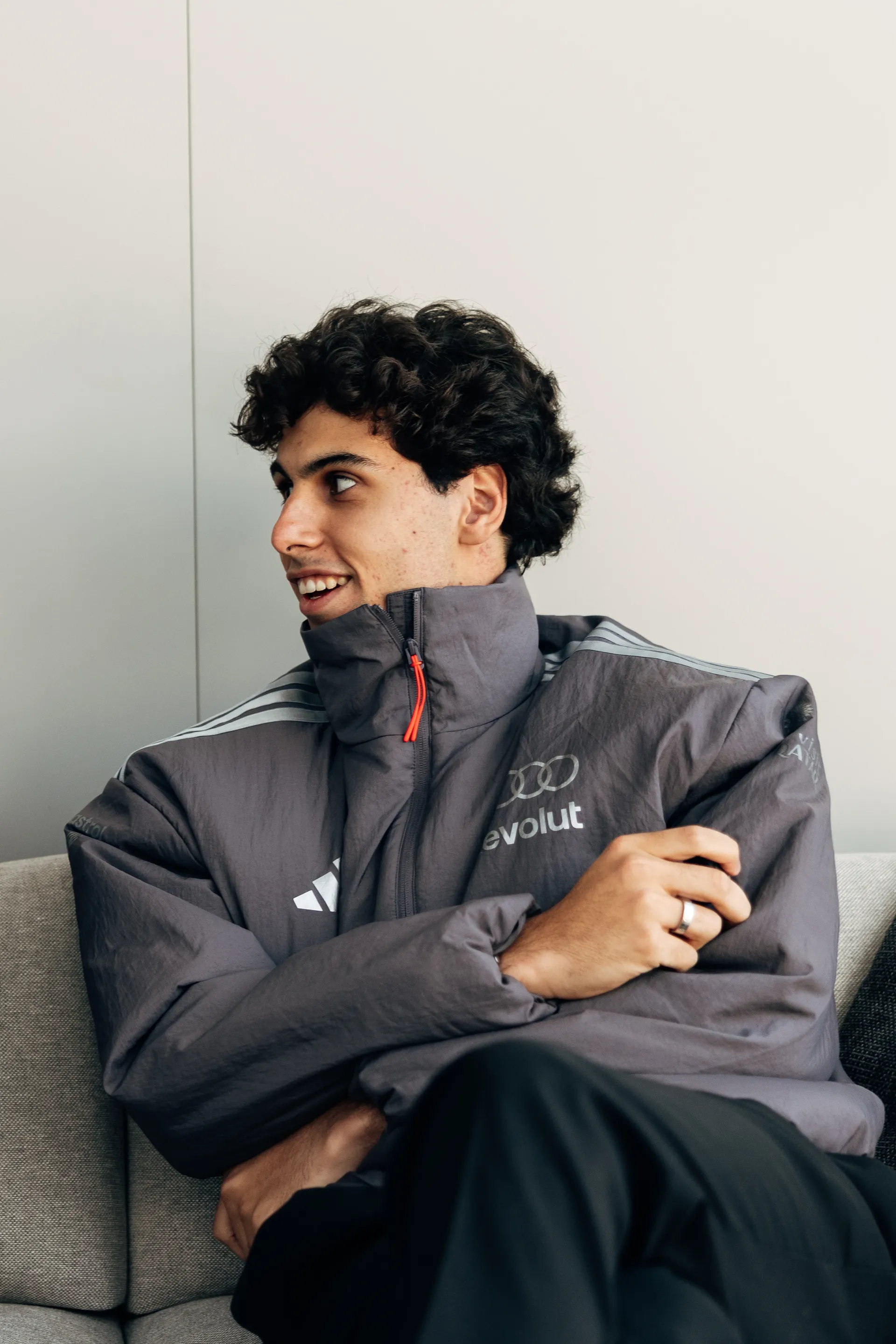 Gabriel Bortoleto seated indoors wearing Audi Revolut F1® Team jacket, looking to the side.