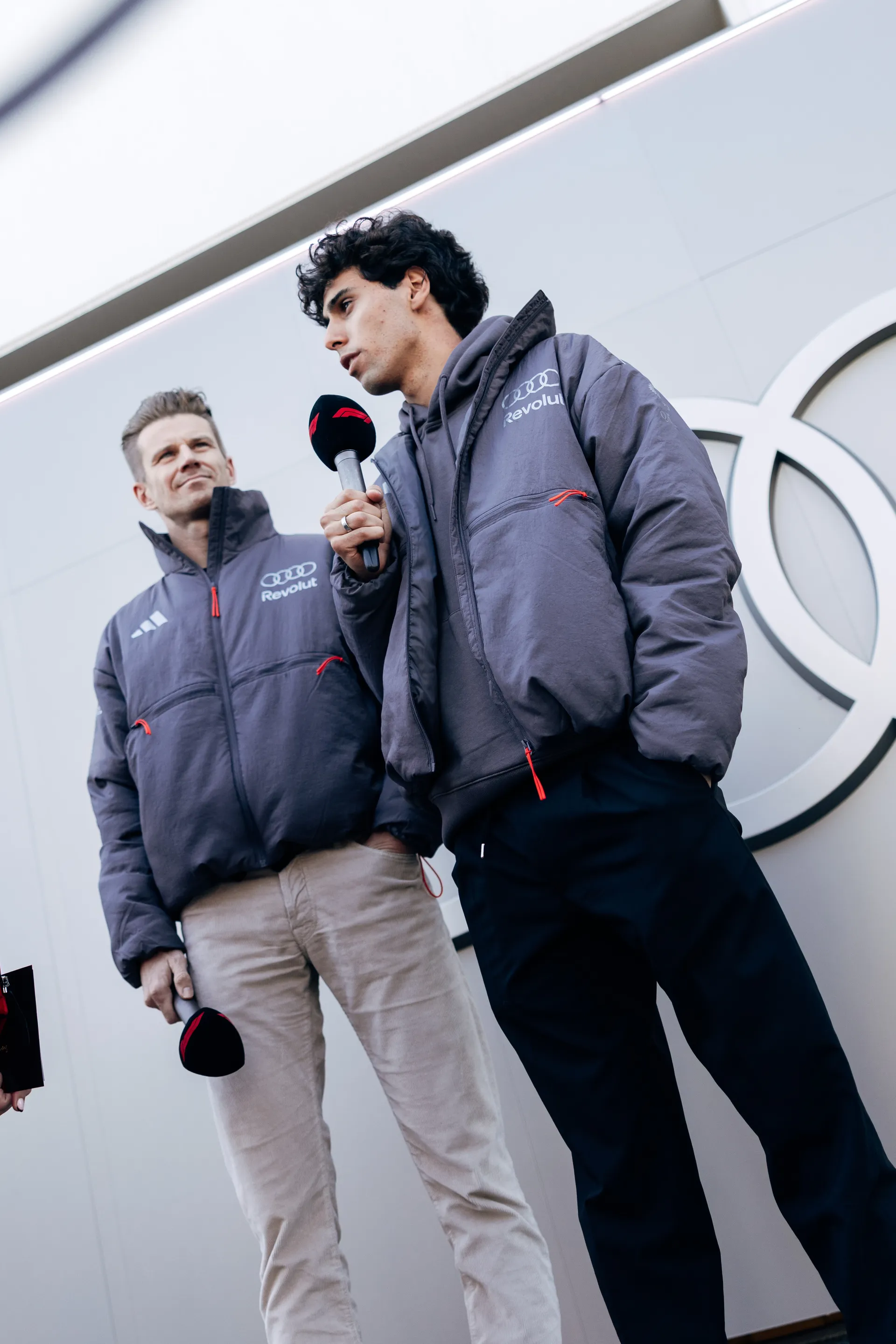 Gabriel Bortoleto speaking into microphone during media session, with Nico Hulkenberg standing beside him.