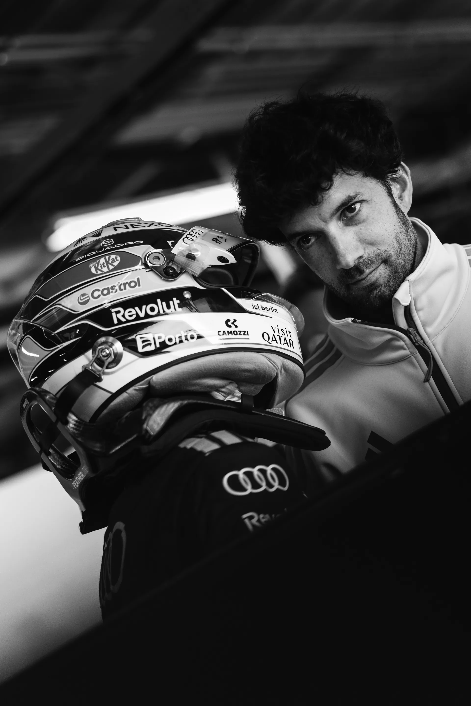 Gabriel Bortoleto helmet in black and white portrait next in the Audi Revolut F1® Team garage.