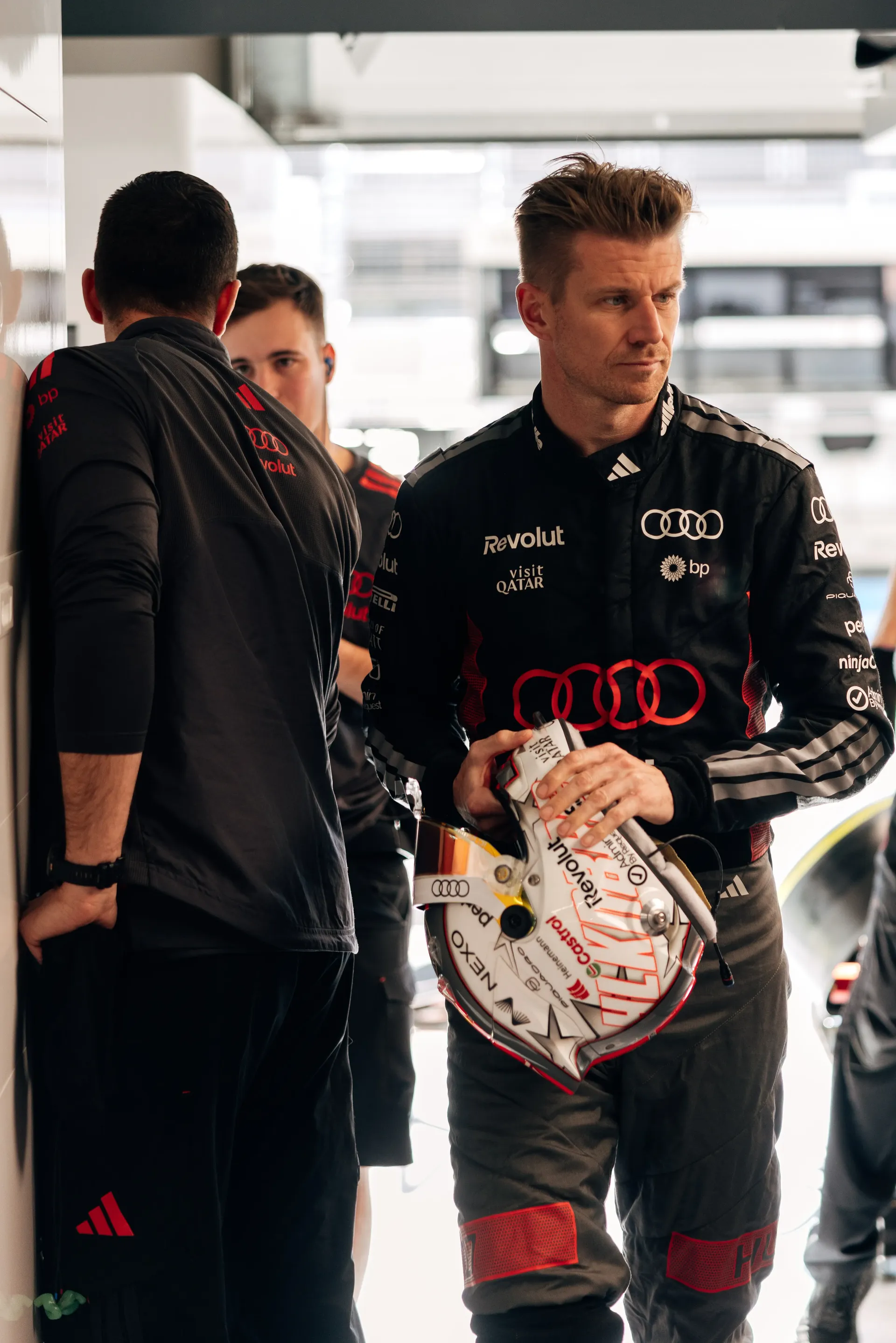 Nico Hulkenberg holding his helmet inside the Audi Revolut F1® Team garage.