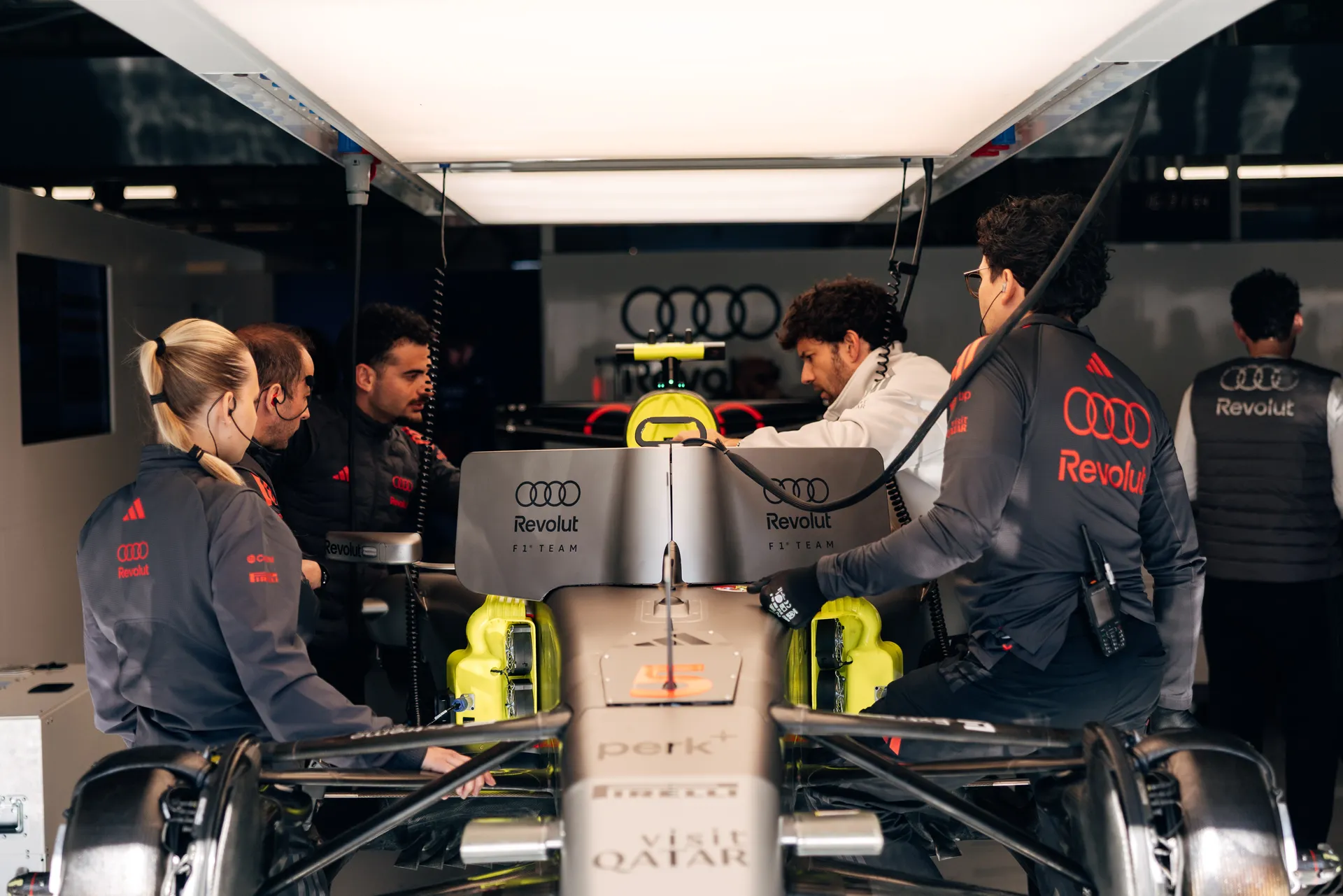 Audi Revolut F1® Team mechanics working on the car inside the garage, front view.