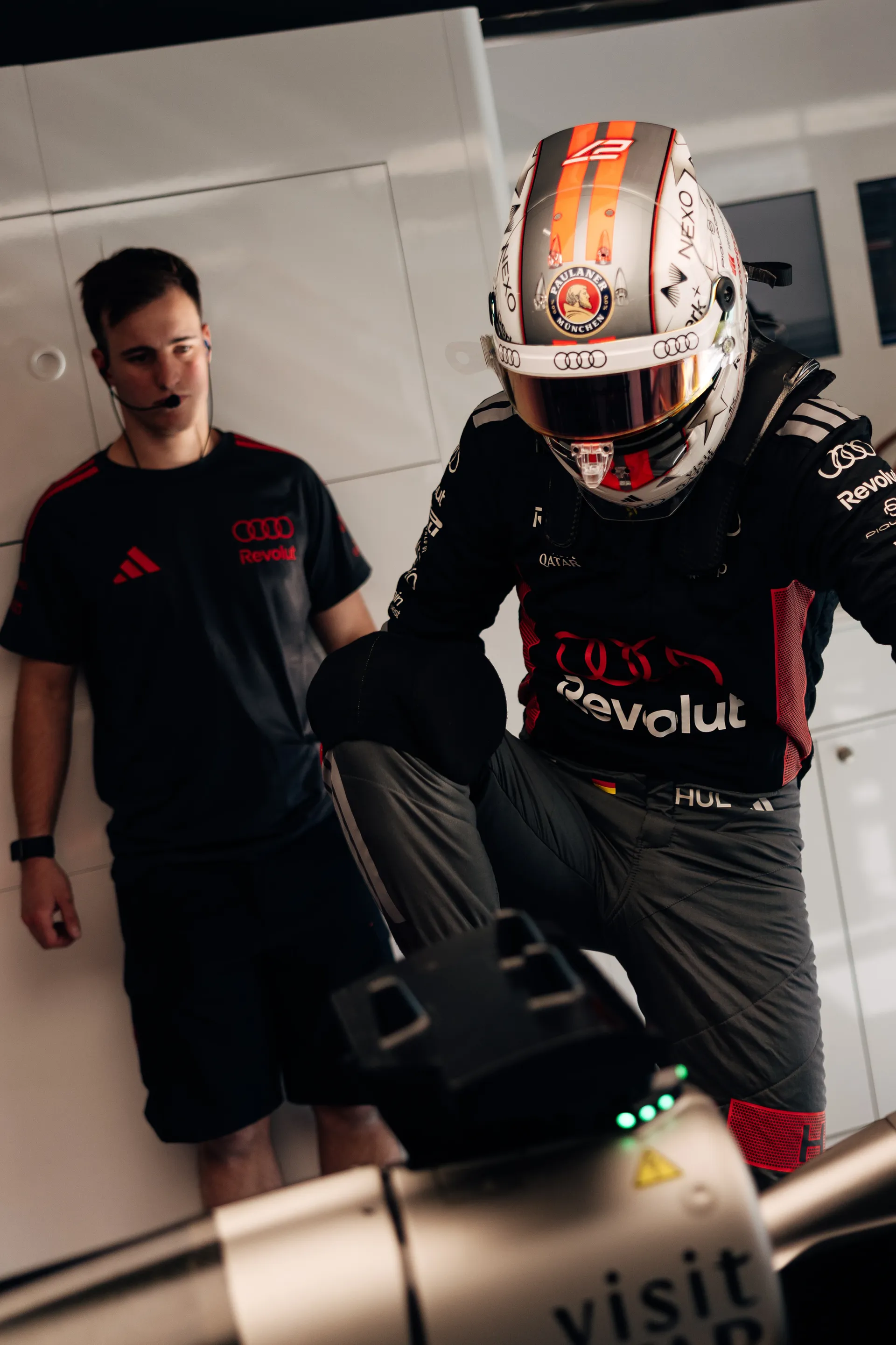 Nico Hulkenberg stepping into the car in full race gear, preparing for a session.