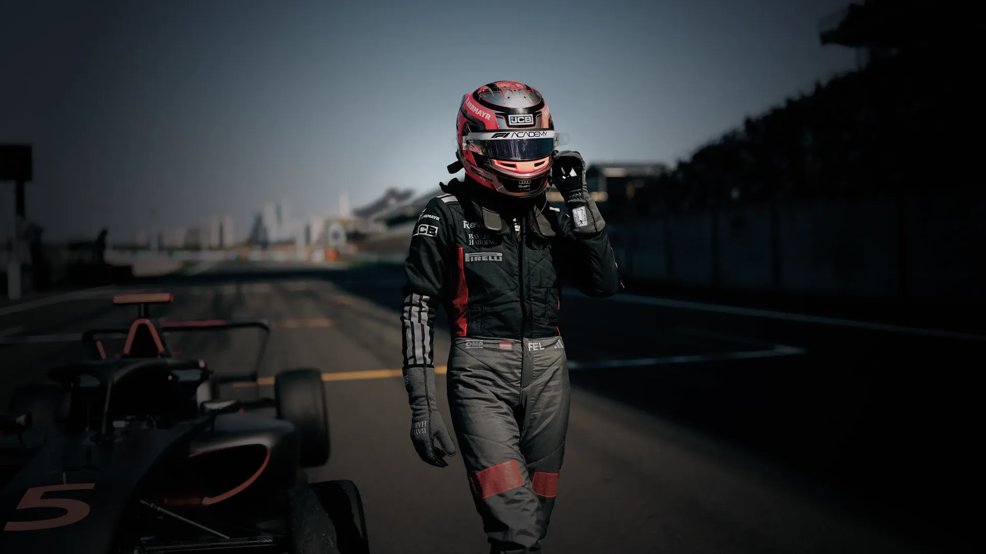 Driver Emma Felbermayr walking next to the Audi Revolut F1® Team Academy car on the racetrack Chinese Grand Prix at Shanghai
