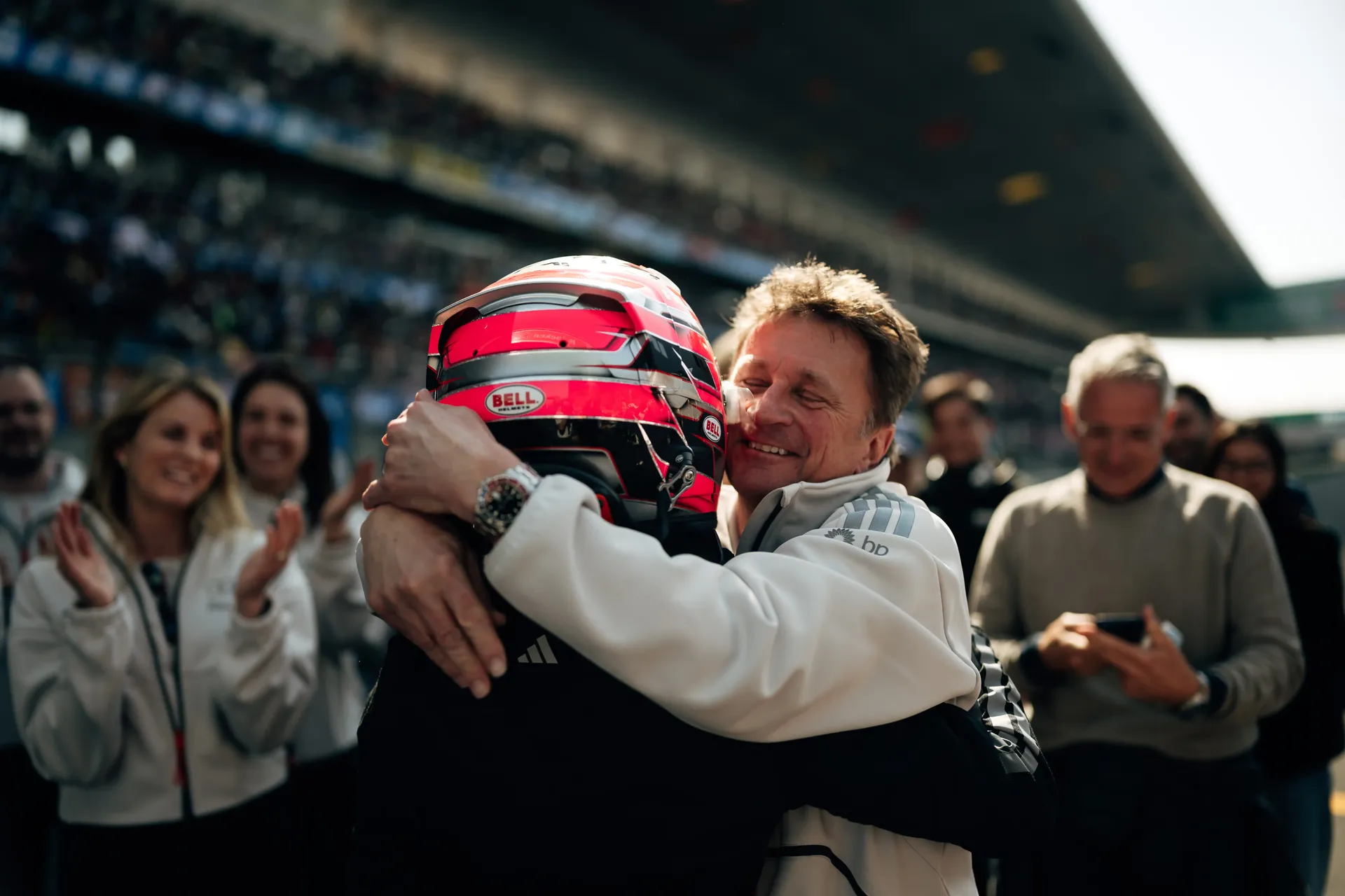 Closeup of director Allan McNish cheering and hugging driver Emma Felbermayr at the Audi Revolut F1® Team Academy car on the racetrack Chinese Grand Prix at Shanghai