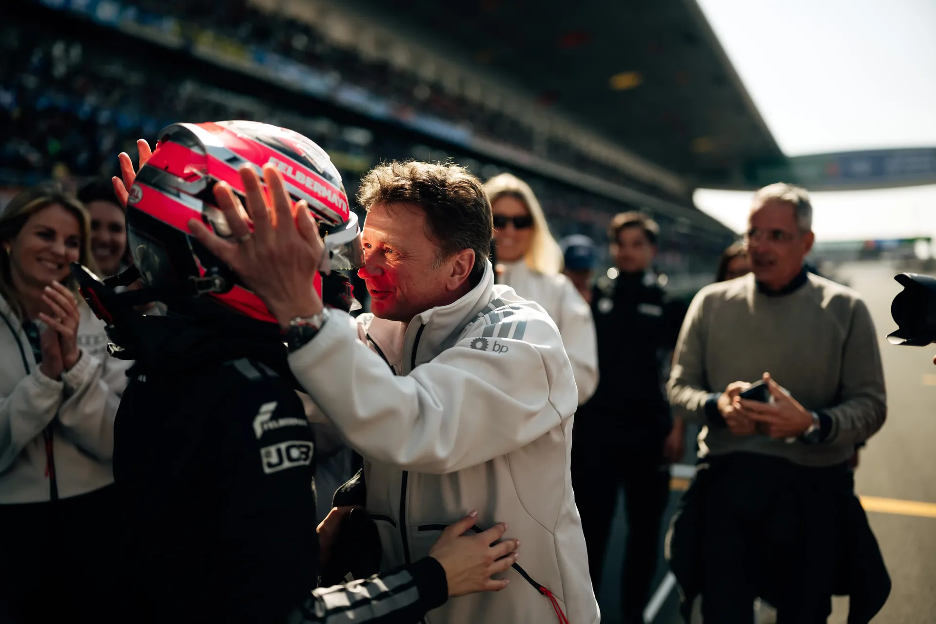 Closeup of director Allan McNish motivating and holding Emma Felbermayrs helmet at the Audi Revolut F1® Team Academy car on the racetrack Chinese Grand Prix at Shanghai