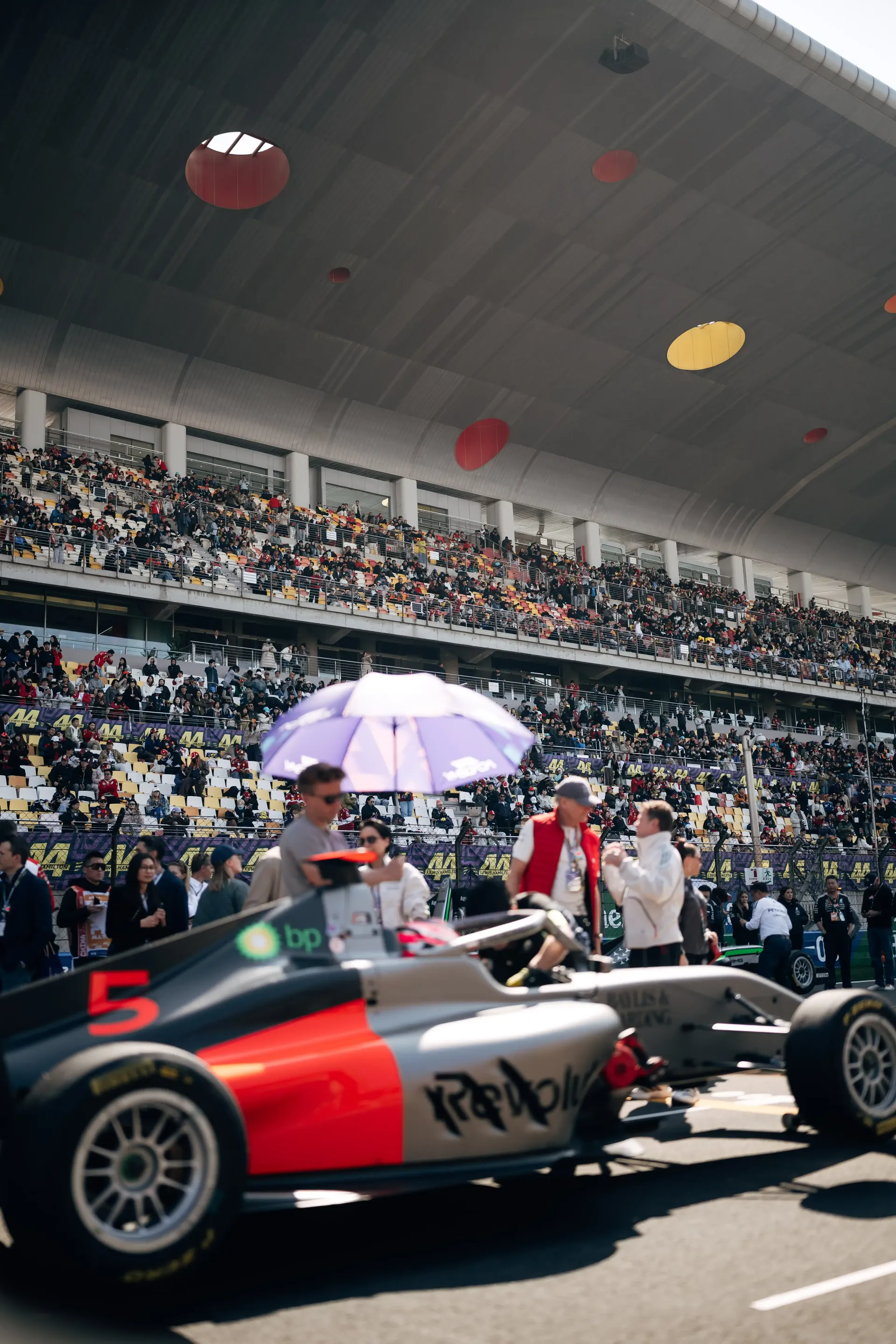 Emma Felbermayr seated in the Audi Revolut F1® Team car on the Shanghai grid surrounded by mechanics and team members.