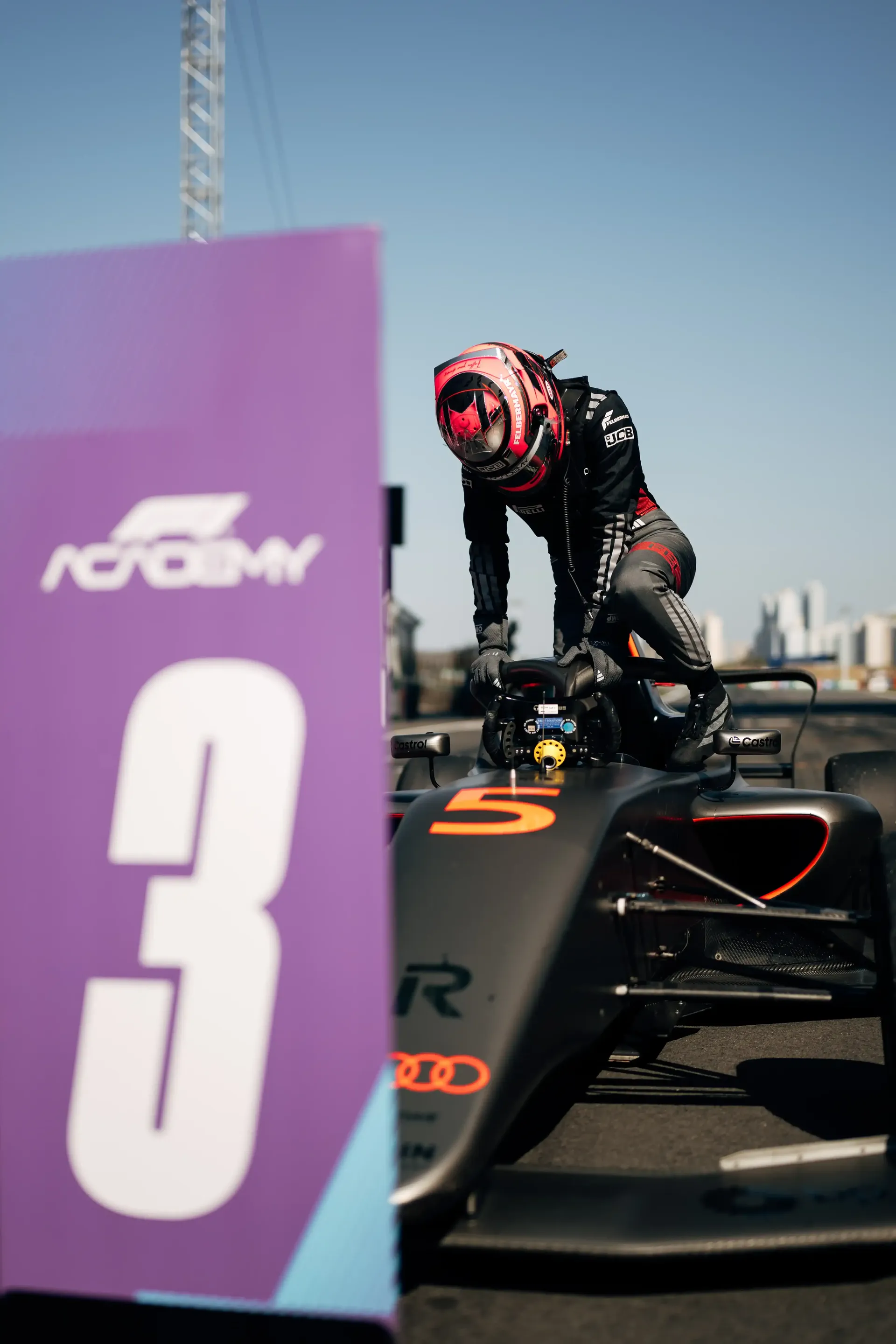 Emma Felbermayr standing beside the Audi Revolut F1® Team car in the pit lane near the grid position marker during the Chinese Grand Prix.