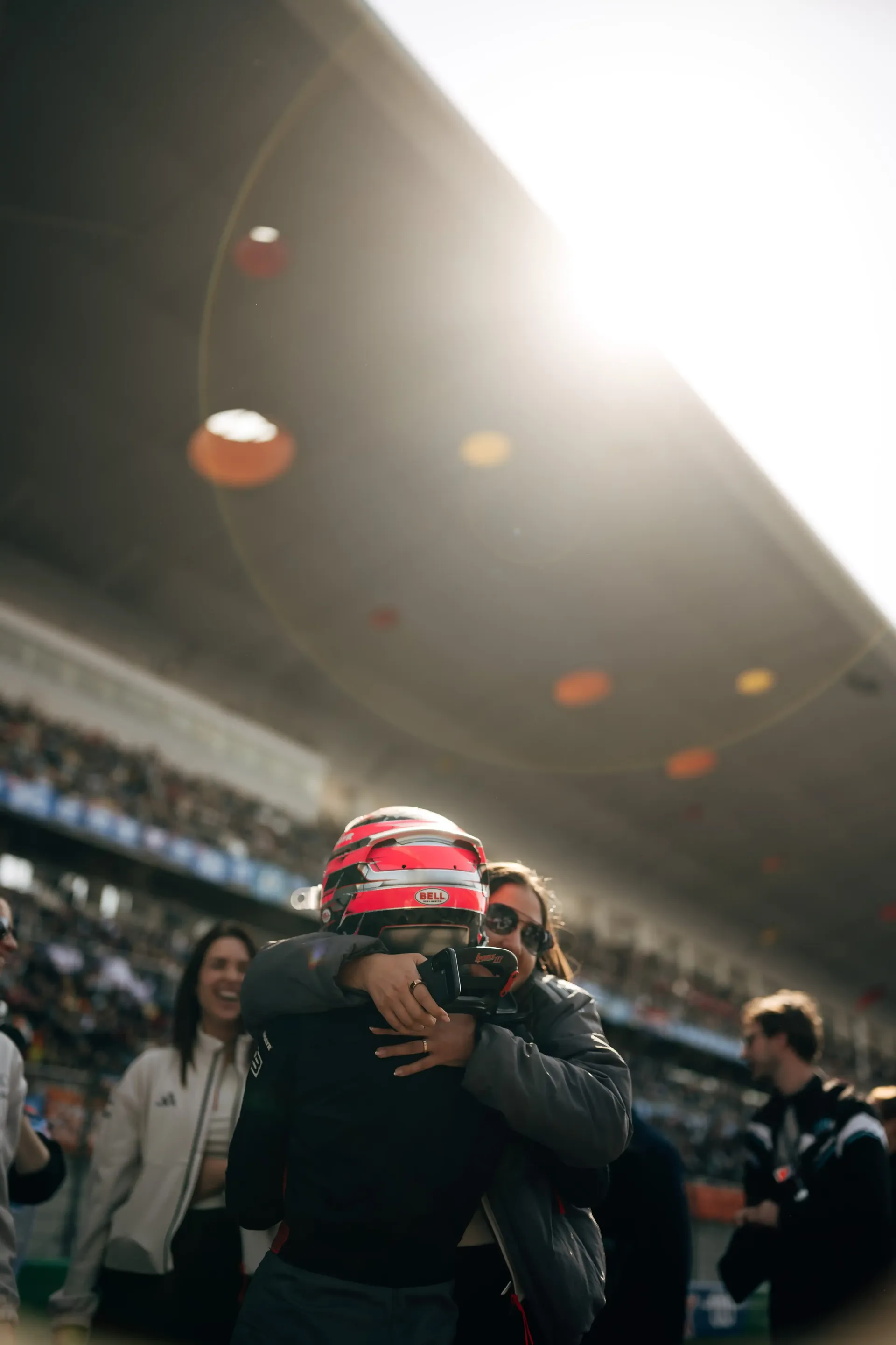 Emma Felbermayr hugging a team member while wearing her racing helmet after a session at the Chinese Grand Prix.