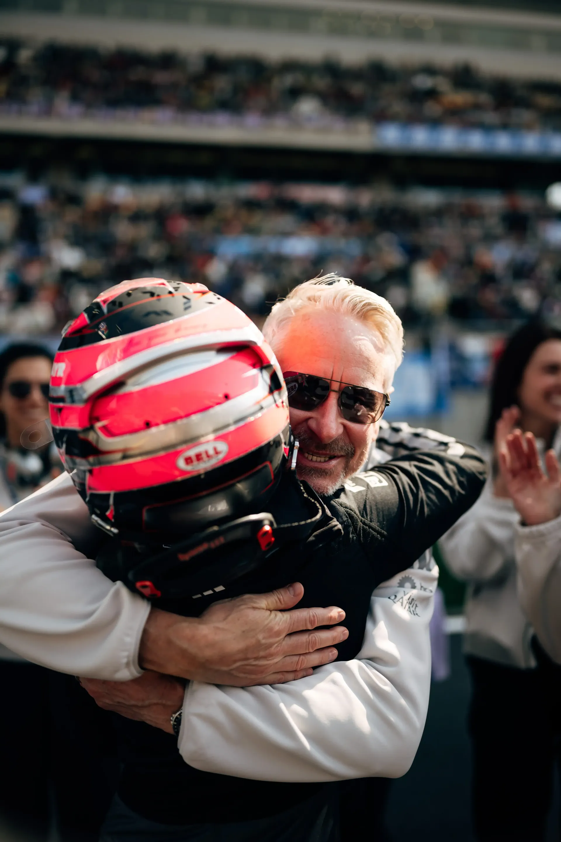 Emma Felbermayr hugging a team principal Jonathan Wheatley while wearing her racing helmet after a session at the Chinese Grand Prix.