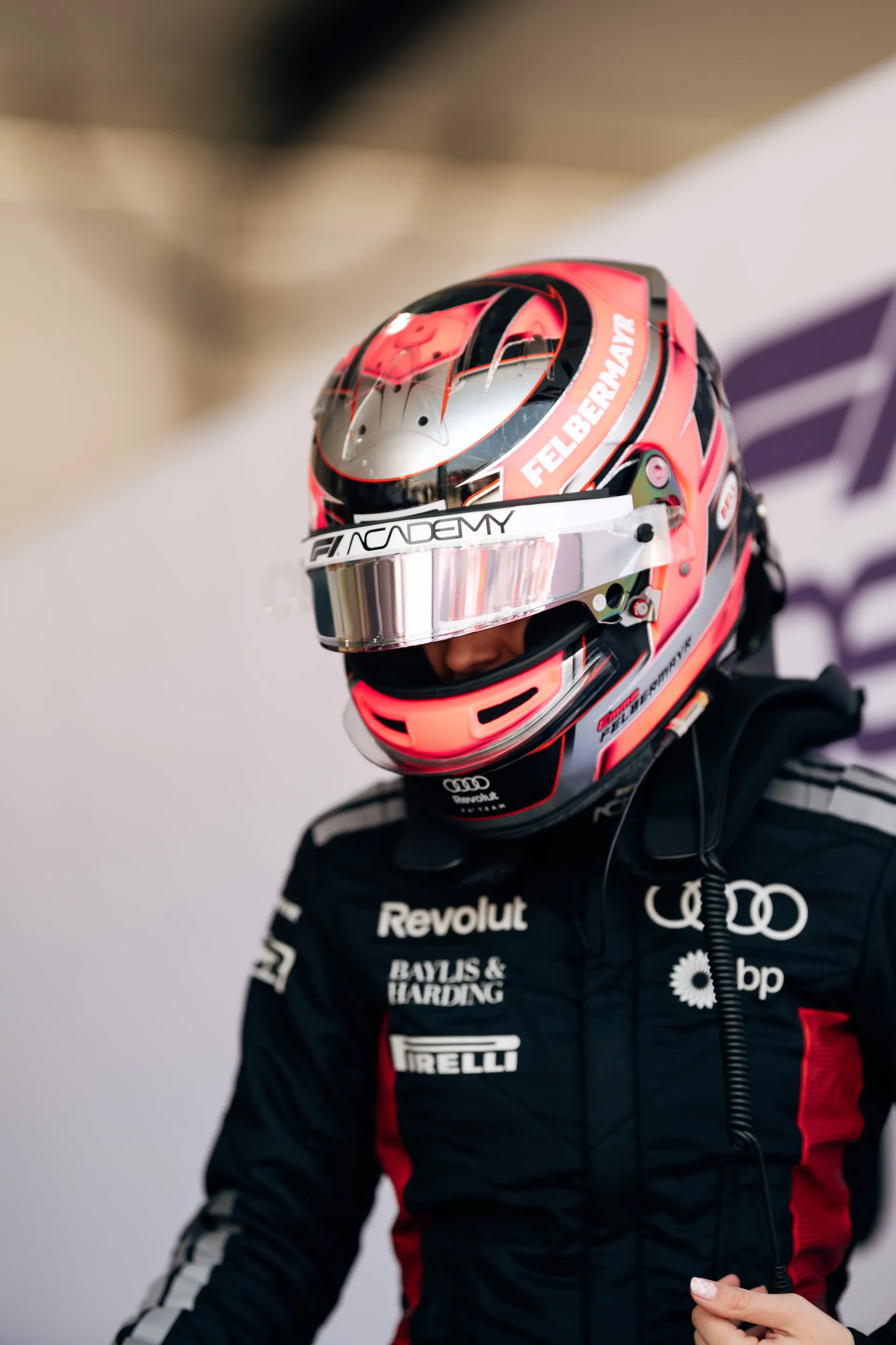 Portrait of Emma Felbermayr, Audi Revolut F1® Team Academy driver, wearing a racing suit and helmet during a Formula 1 test session.