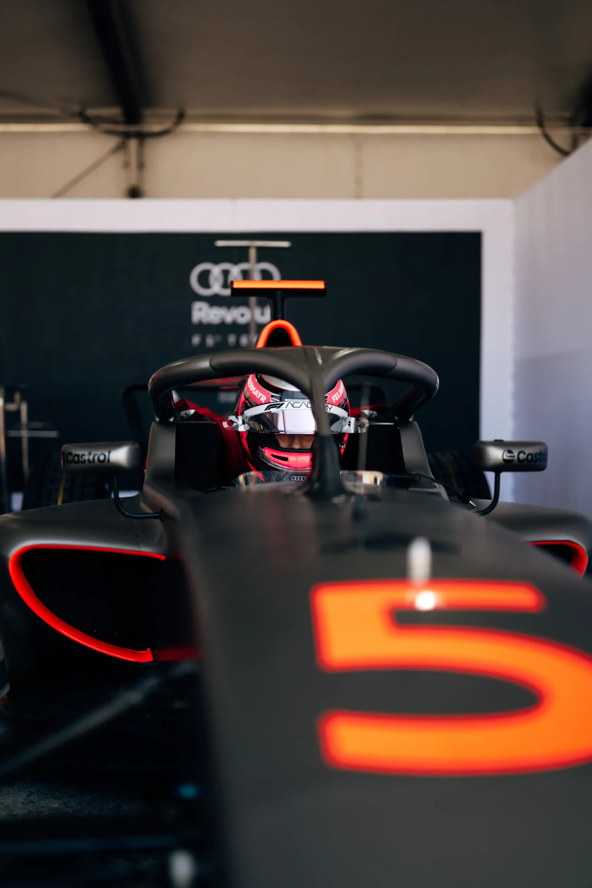 Close-up of Emma Felbermayr, Audi Revolut F1® Team Academy driver, inside the Formula 1 car cockpit during preparation.
