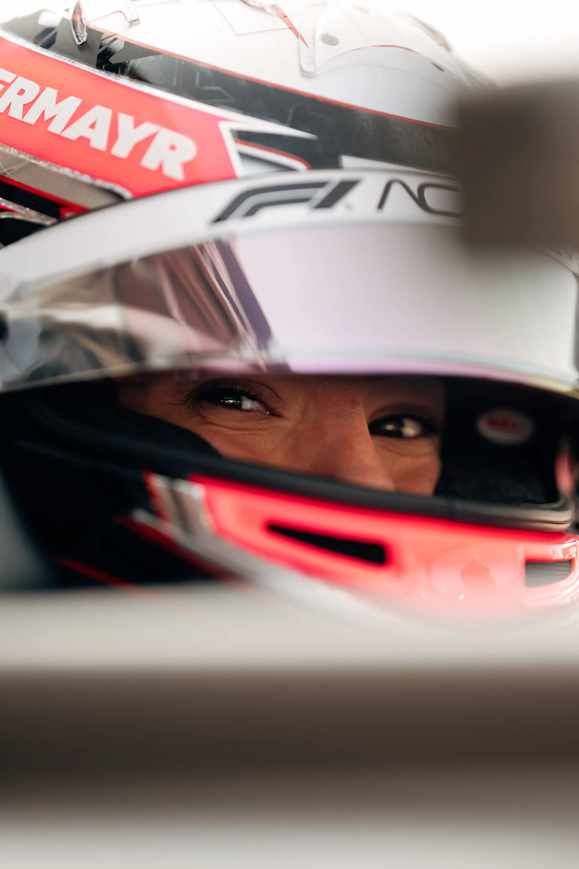 Close-up portrait of Emma Felbermayr, Audi Revolut F1® Team Academy driver, wearing a helmet inside the Formula 1 car.