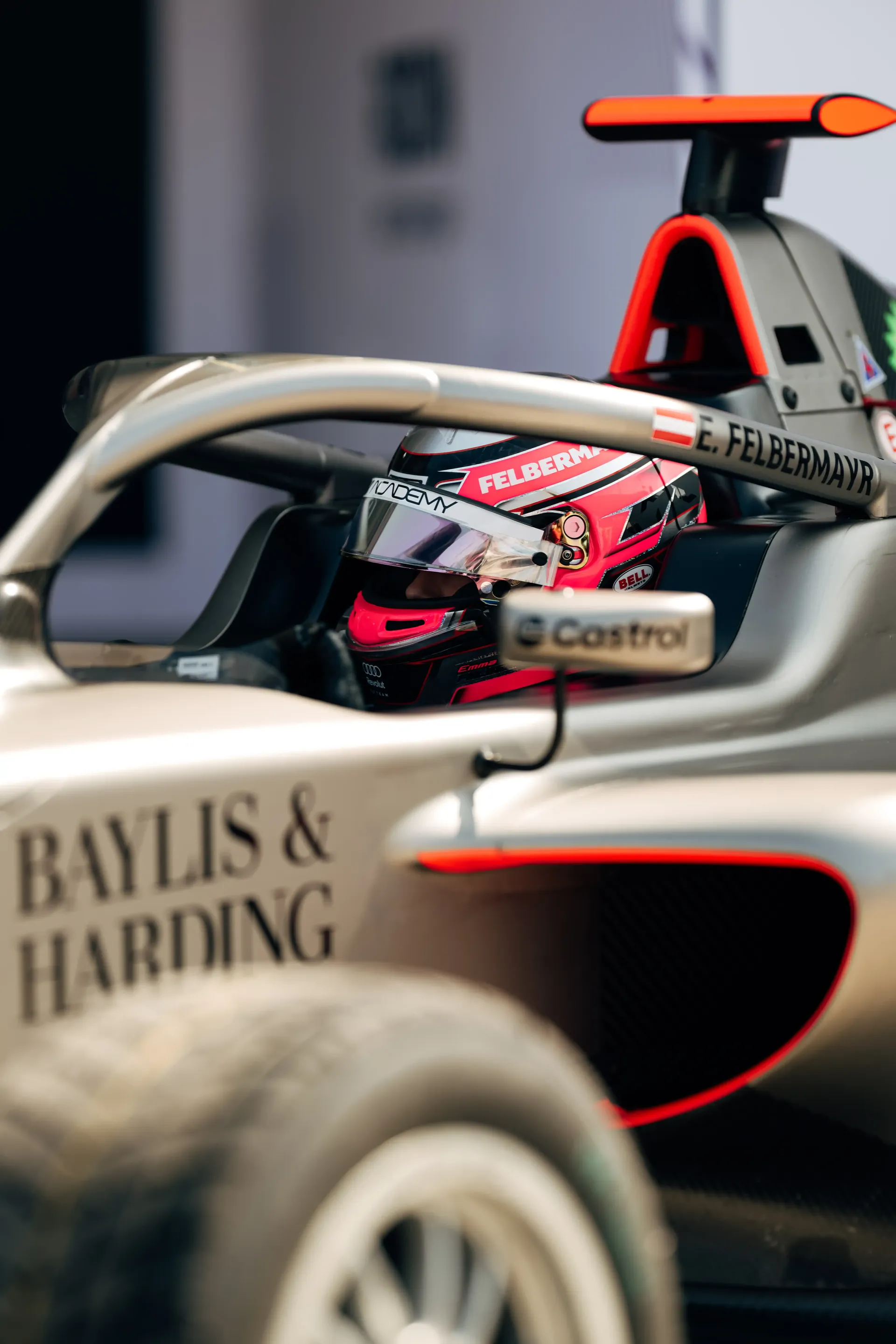 Rear three-quarter view of the Audi Revolut F1® Team Formula 1 car with Emma Felbermayr, Audi Revolut F1® Team Academy driver, seated.
