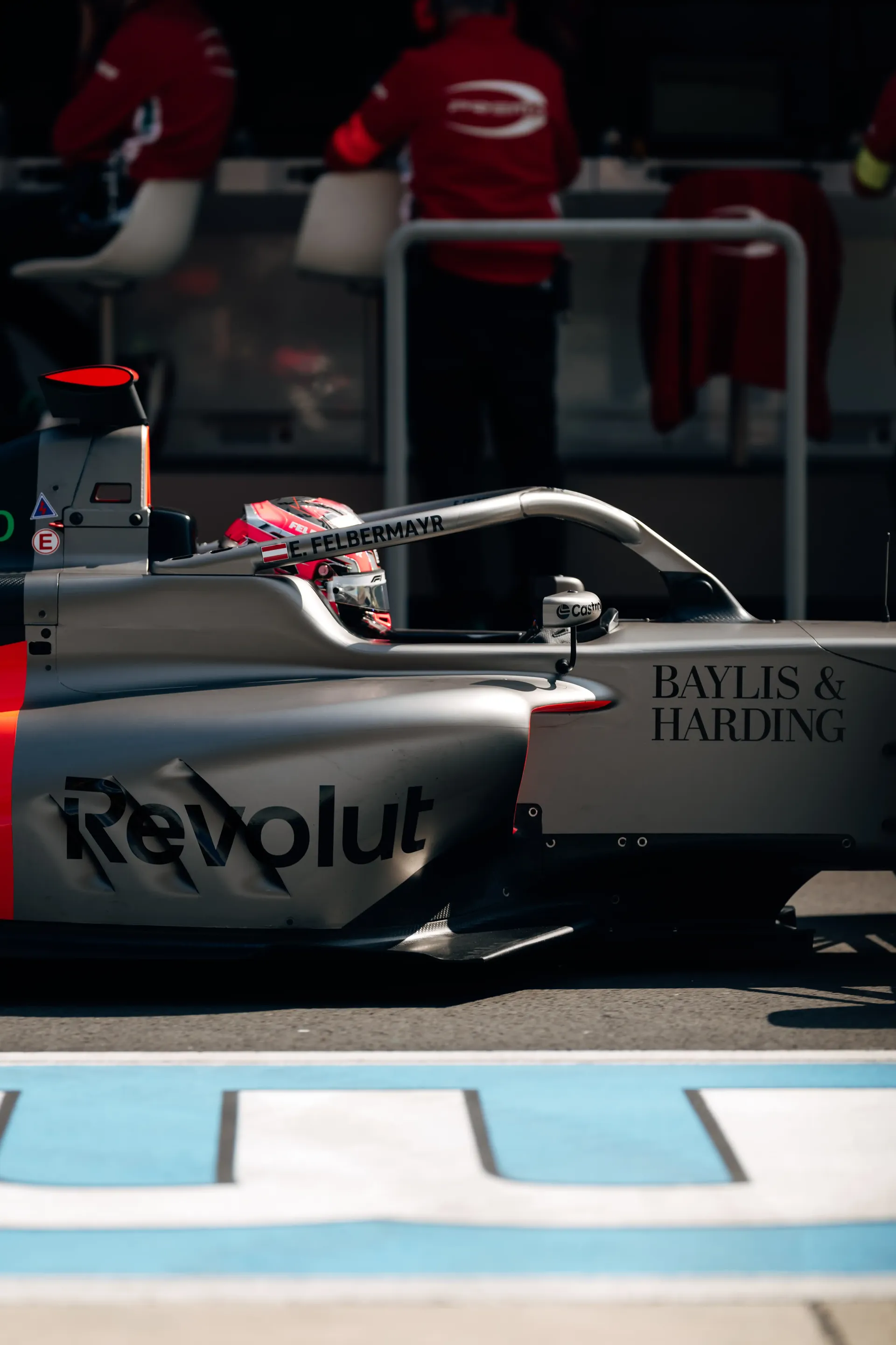 Audi Revolut F1® Team Formula 1 car in the pit lane with Emma Felbermayr, Audi Revolut F1® Team Academy driver, preparing to go on track.