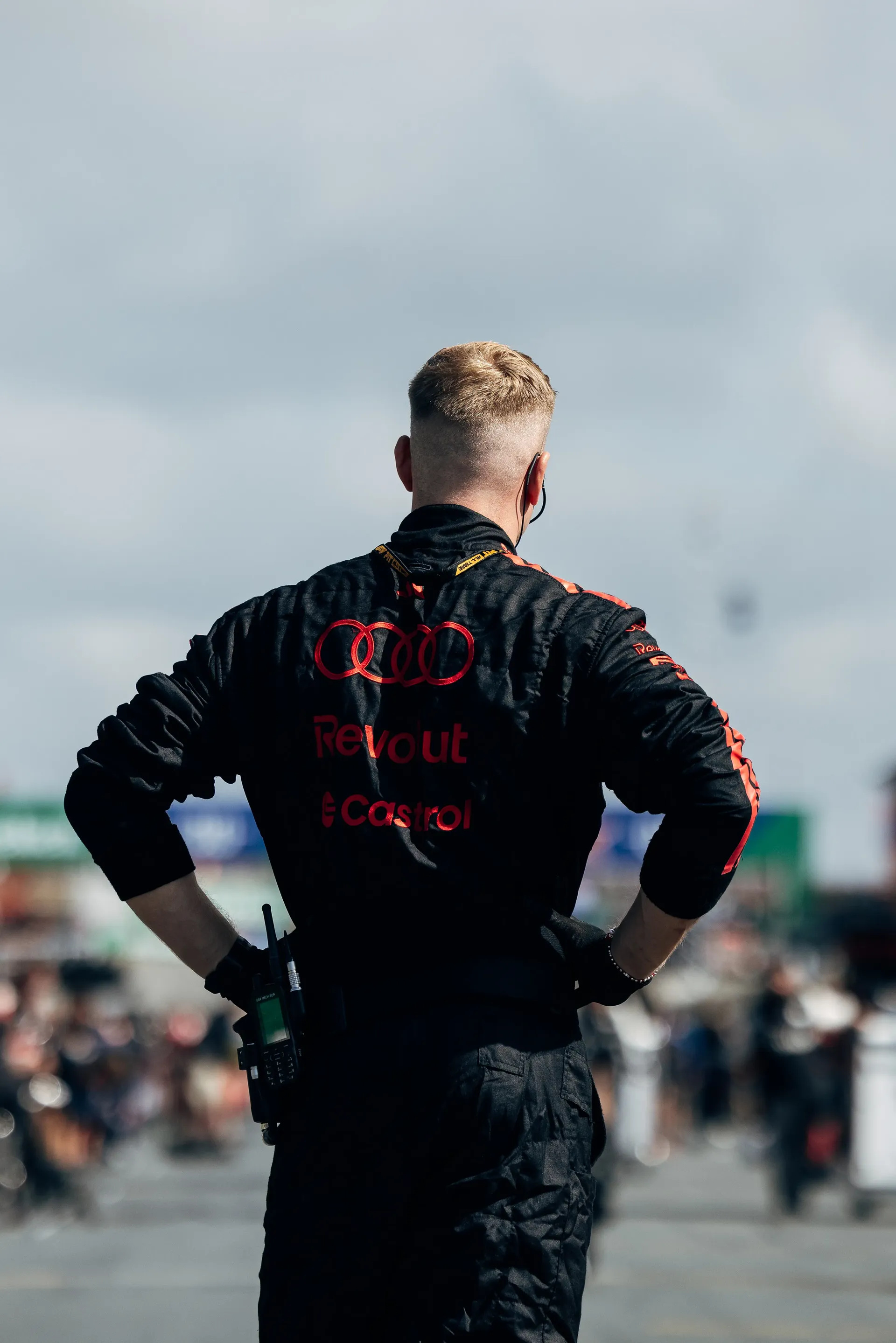 Audi Revolut F1® Team mechanic standing with hands on hips in the paddock.