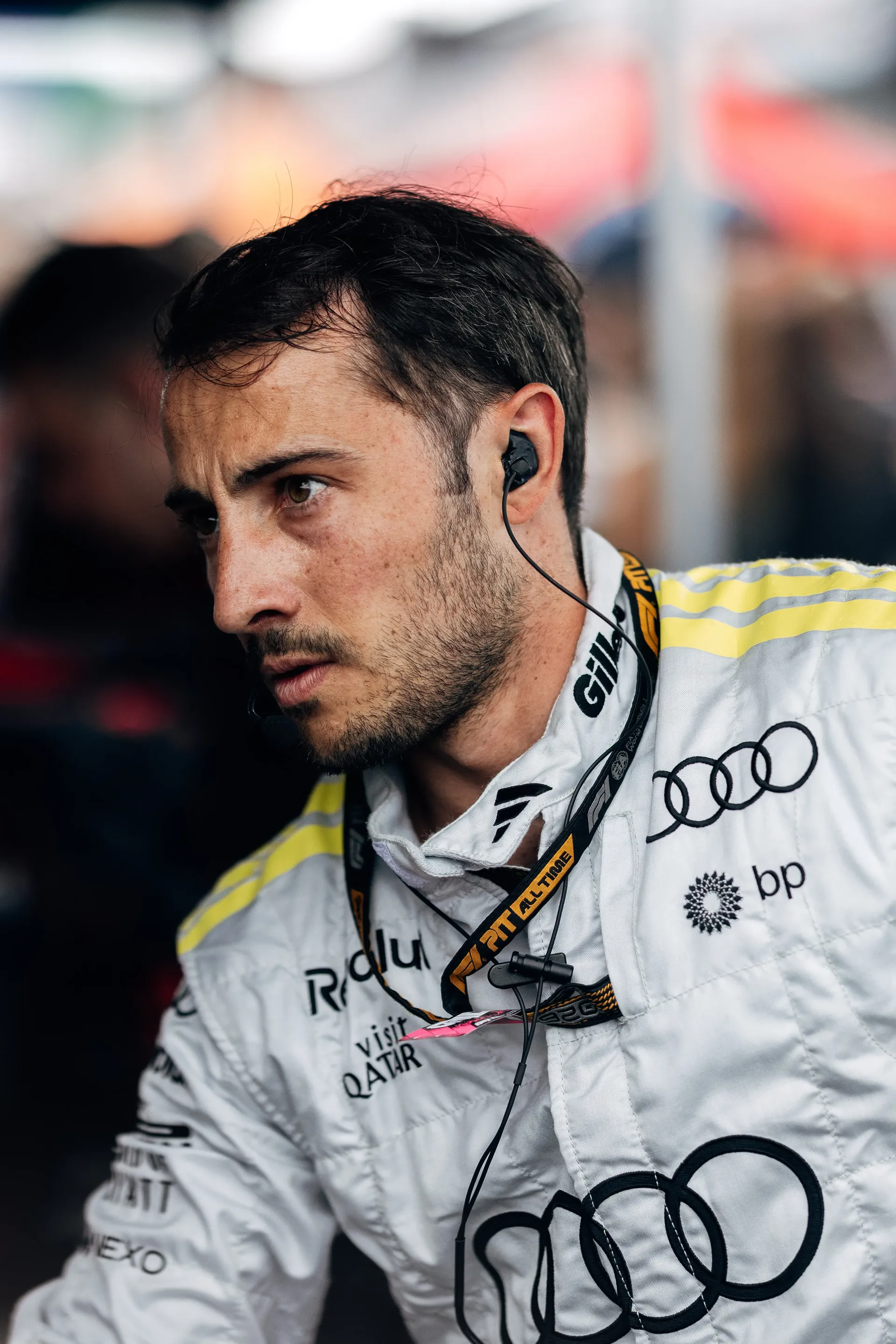 Audi Revolut F1® Team engineer in a white race suit wearing an earpiece in the garage.