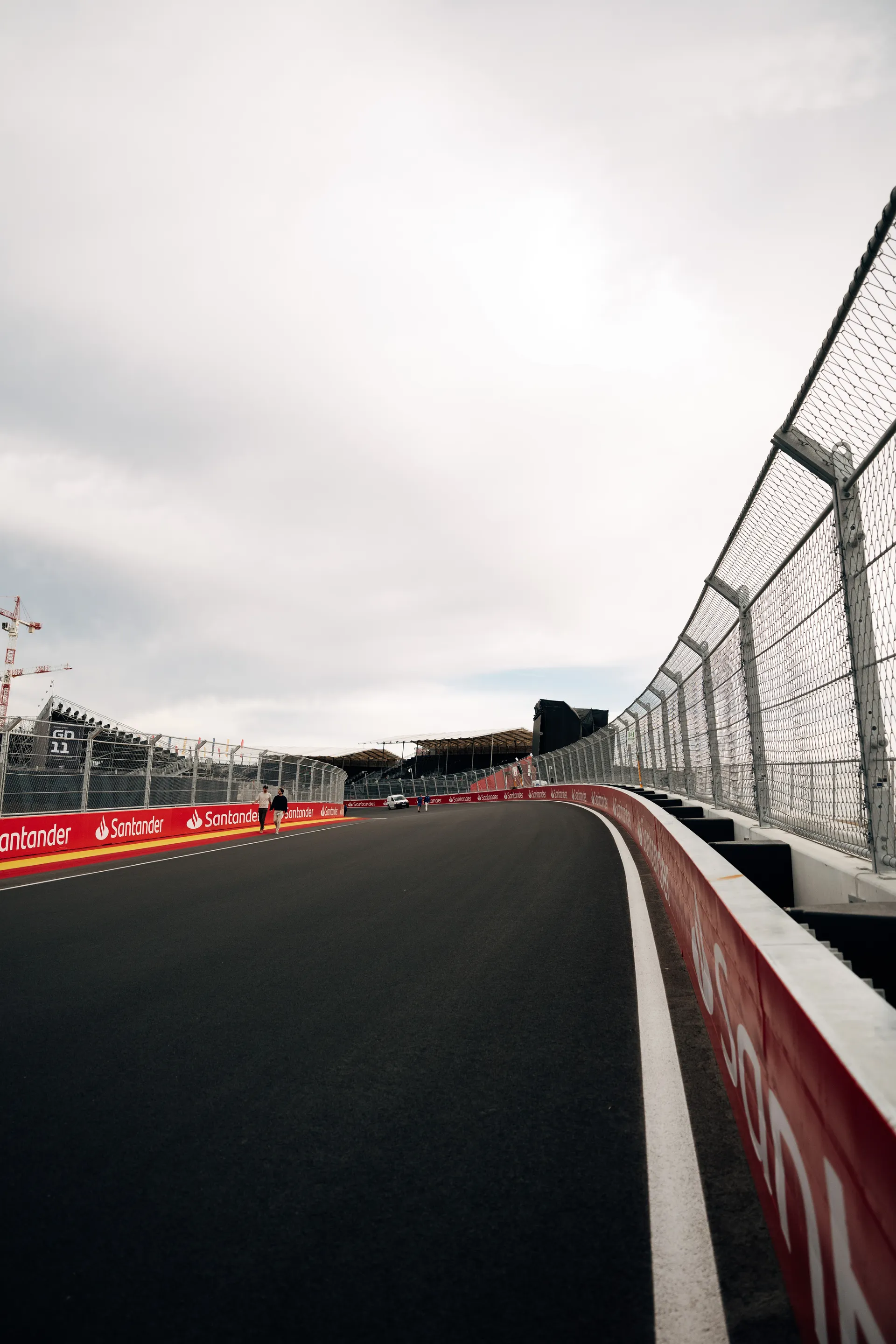 Uphill section of the MADRING circuit in Madrid, lined by safety fencing and trackside barriers.