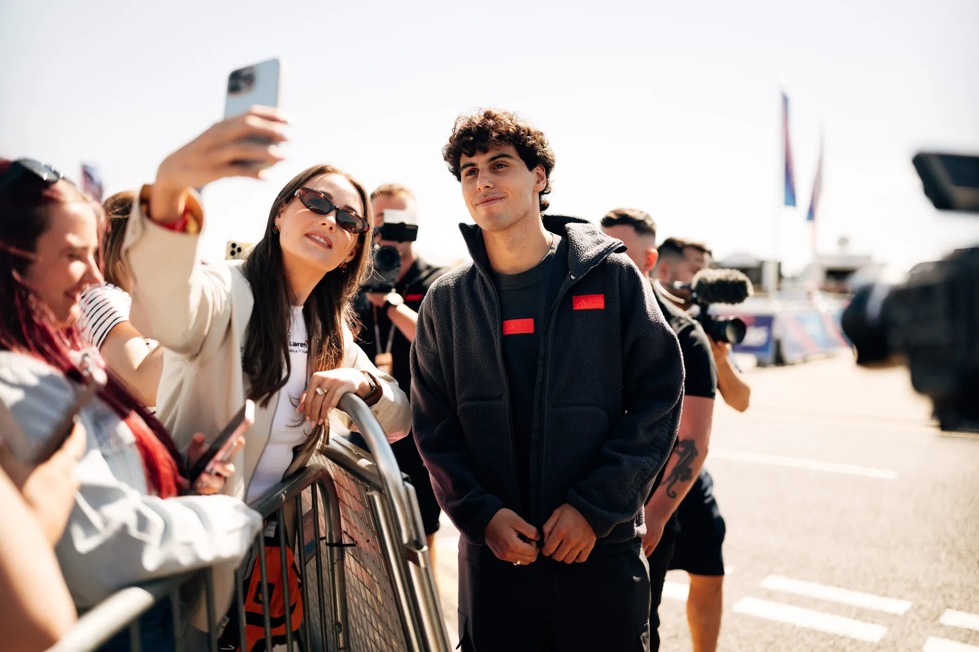 Gabriel Bortoleto, driver at the Audi Revolut F1® Team, greets fans during his arrival at the British Grand Prix wearing the adidas Elevated Fanwear Collection.