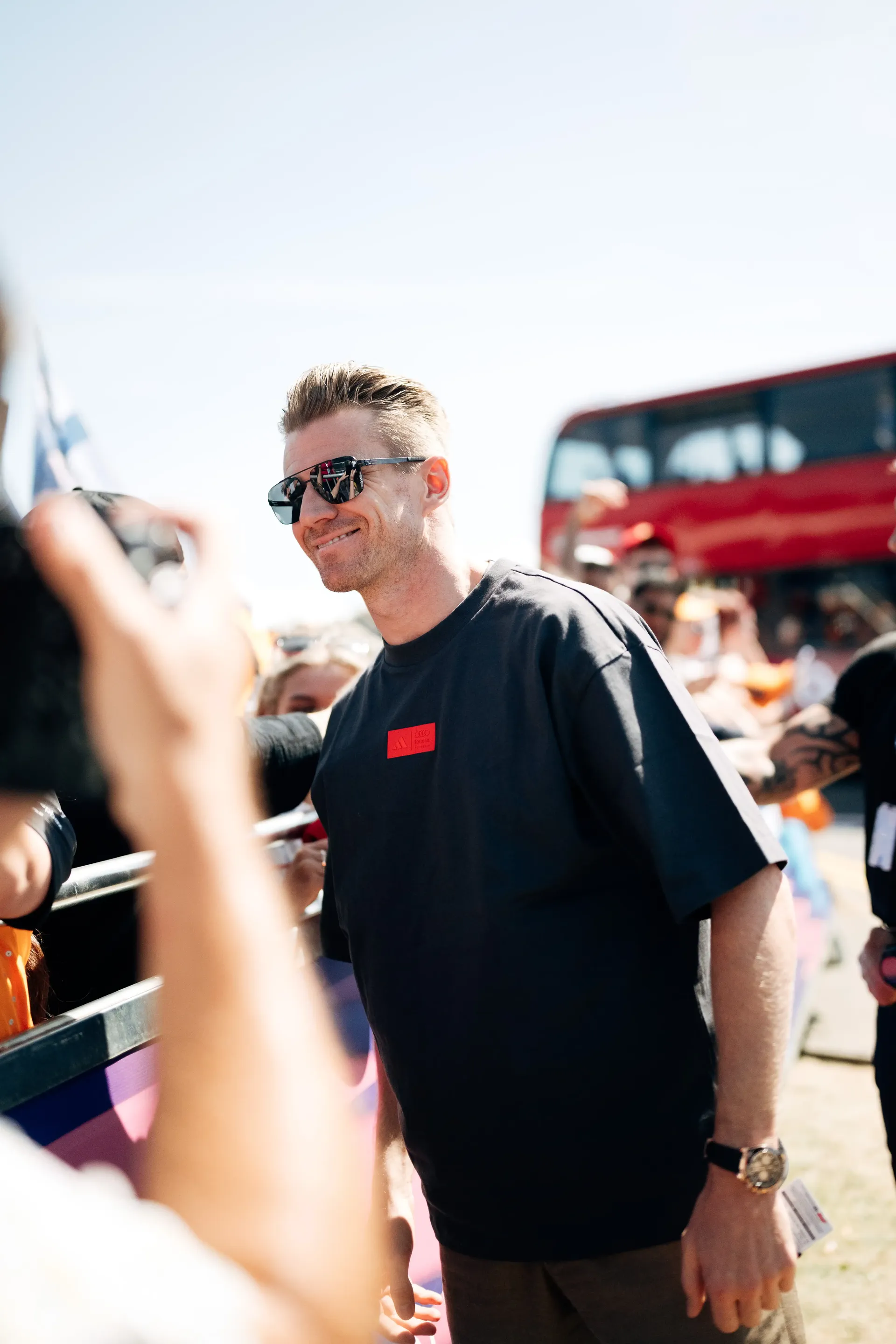Nico Hulkenberg, driver at the Audi Revolut F1® Team, greets fans during his arrival at the British Grand Prix wearing the adidas Elevated Fanwear Collection.