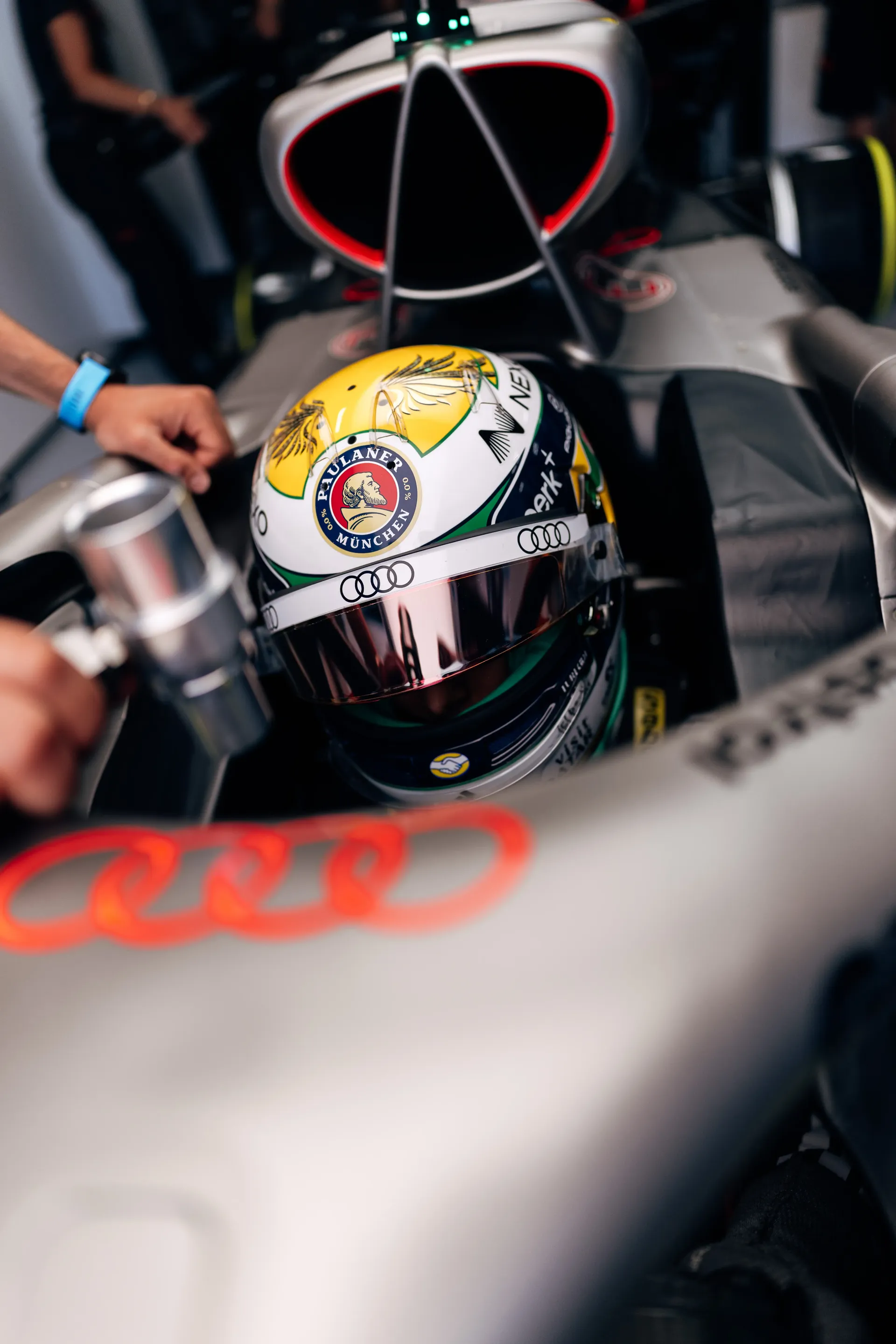 Audi Revolut F1® Team driver Gabriel Bortoleto sits in the Audi Revolut F1® Team Audi R26 cockpit while Audi Revolut F1® Team mechanics make final preparations before FP3.