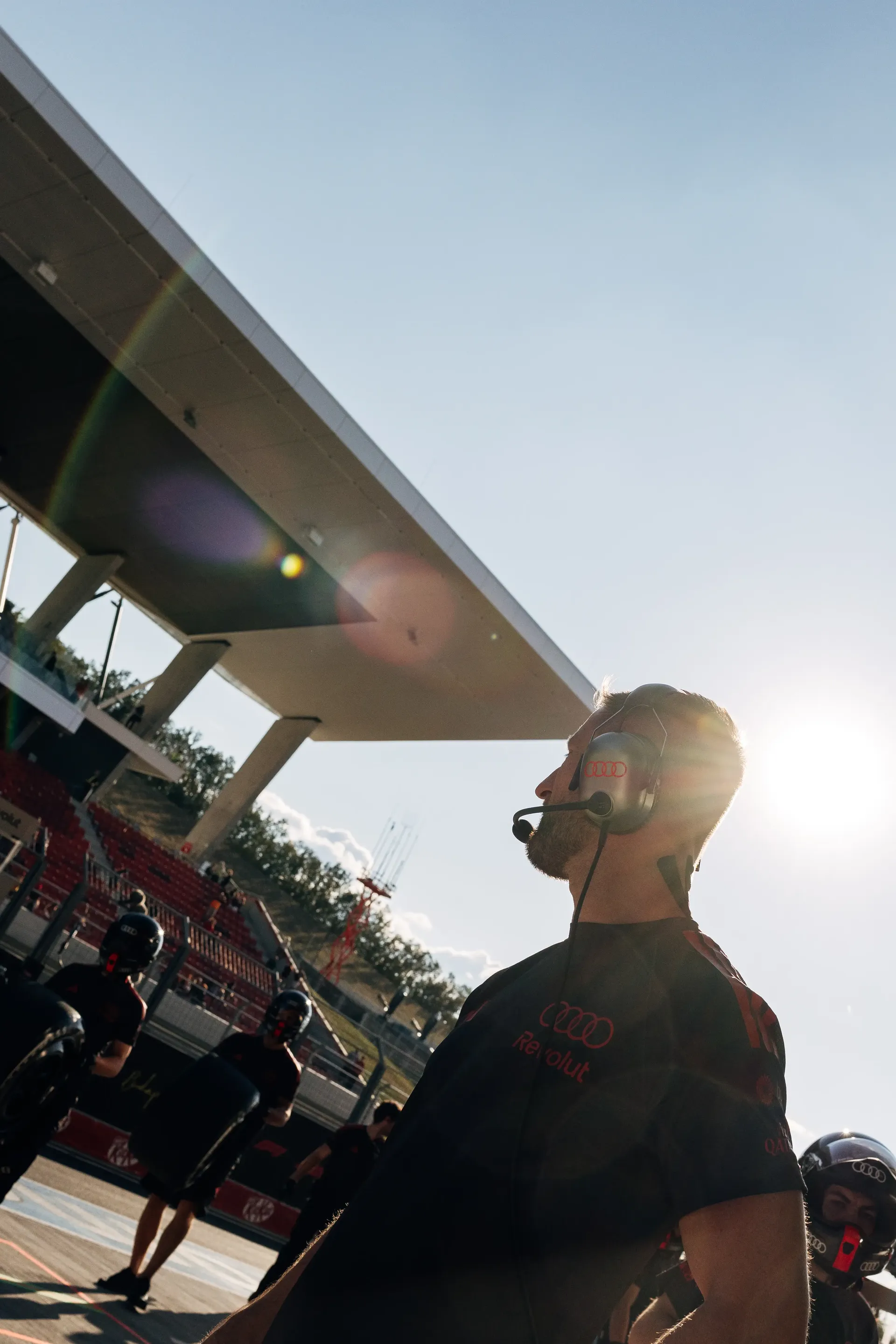 An Audi Revolut F1® Team mechanic stands in the pit lane under the afternoon sun before FP2 at the Hungaroring.
