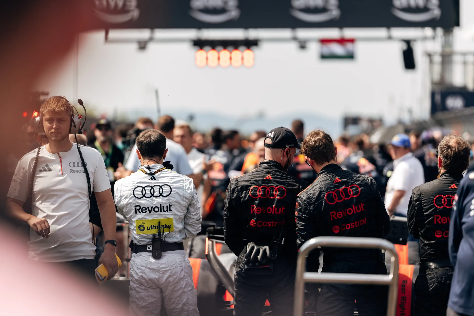 Audi Revolut F1® Team personnel gather on the Hungaroring starting grid during pre-race preparations.