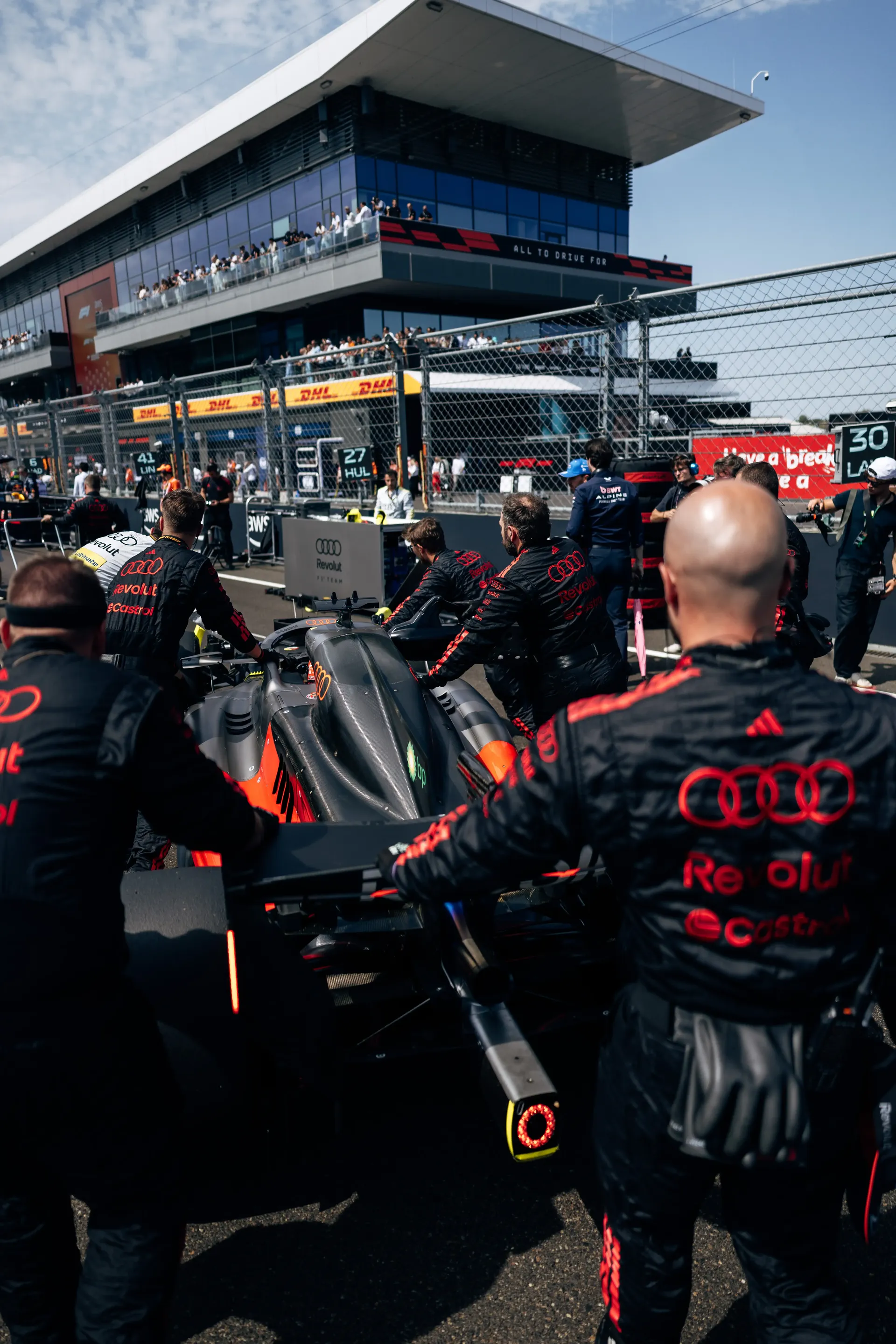 Audi Revolut F1® Team mechanics push the Audi R26 into position on the Hungaroring starting grid.