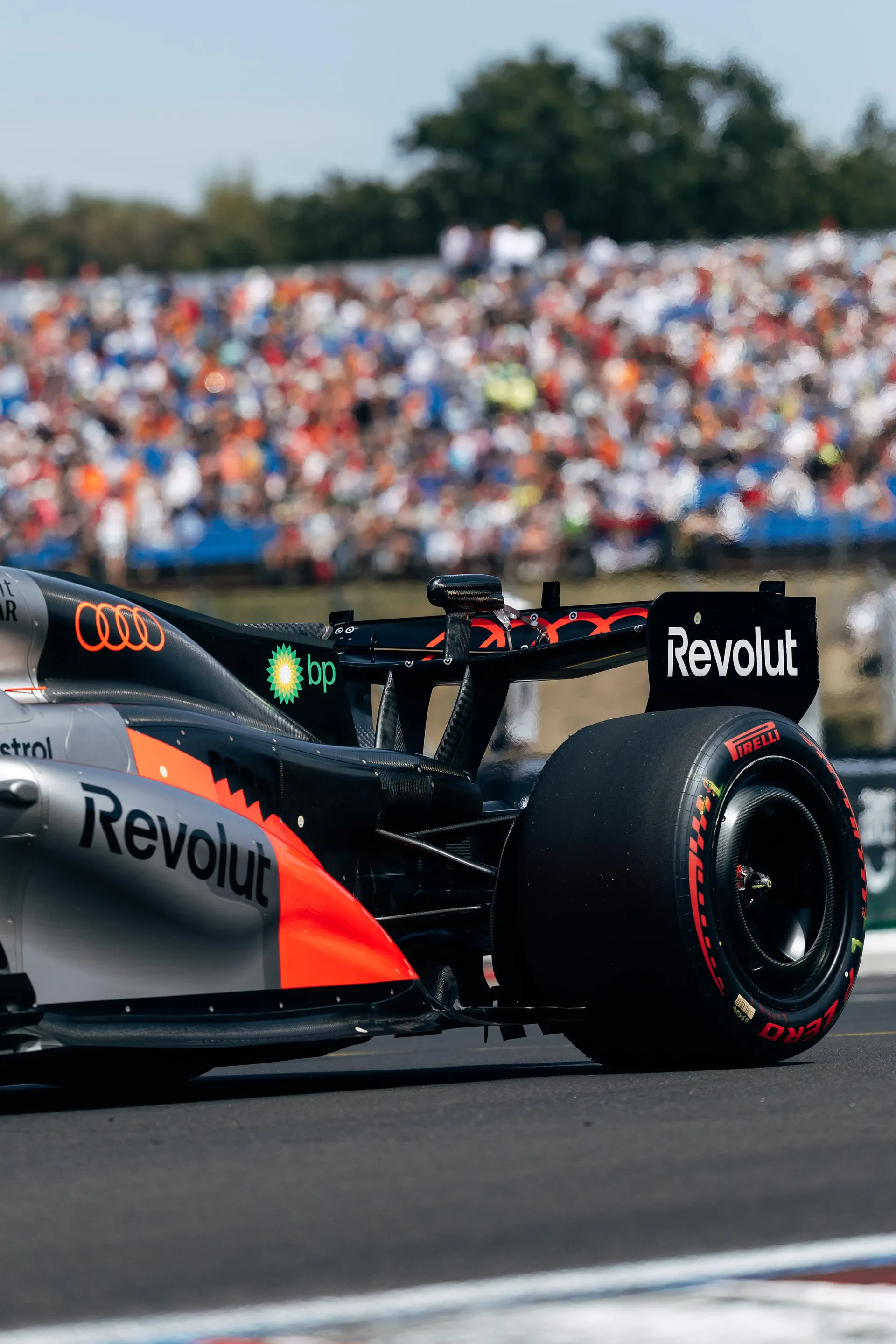 The Audi Revolut F1® Team Audi R26 on track during the Hungarian Grand Prix with the Hungaroring grandstands in the background.