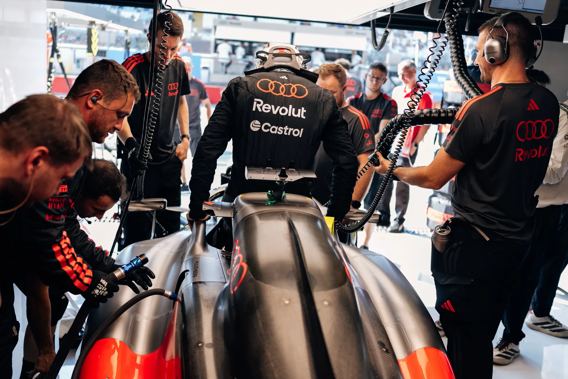 Audi Revolut F1® Team mechanics working on the Audi R26 in the garage