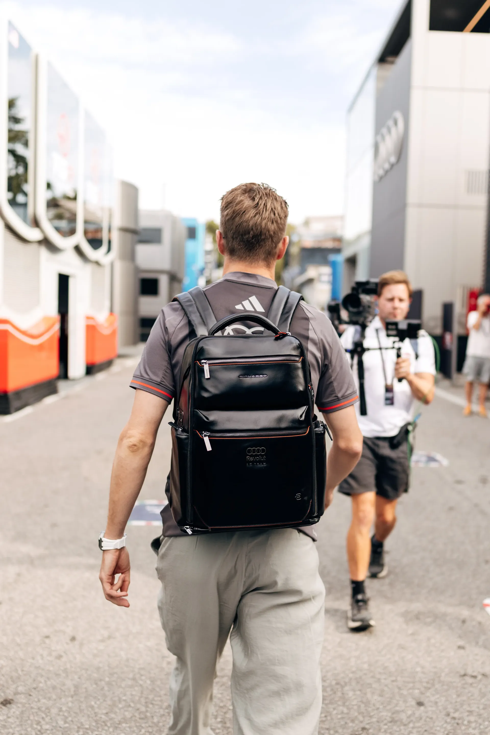 ear three-quarter view of Nico Hulkenberg Audi Revolut F1® Team driver walking between the Audi Revolut F1 Team hospitality units.