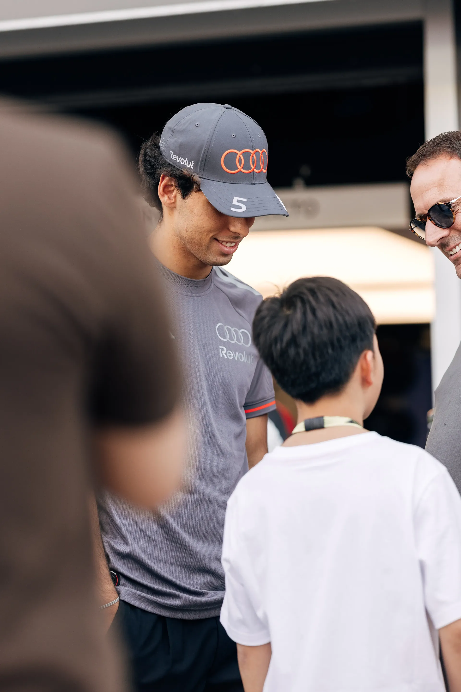 Gabriel Bortoleto of the Audi Revolut F1® Team speaking with a young fan in the paddock.