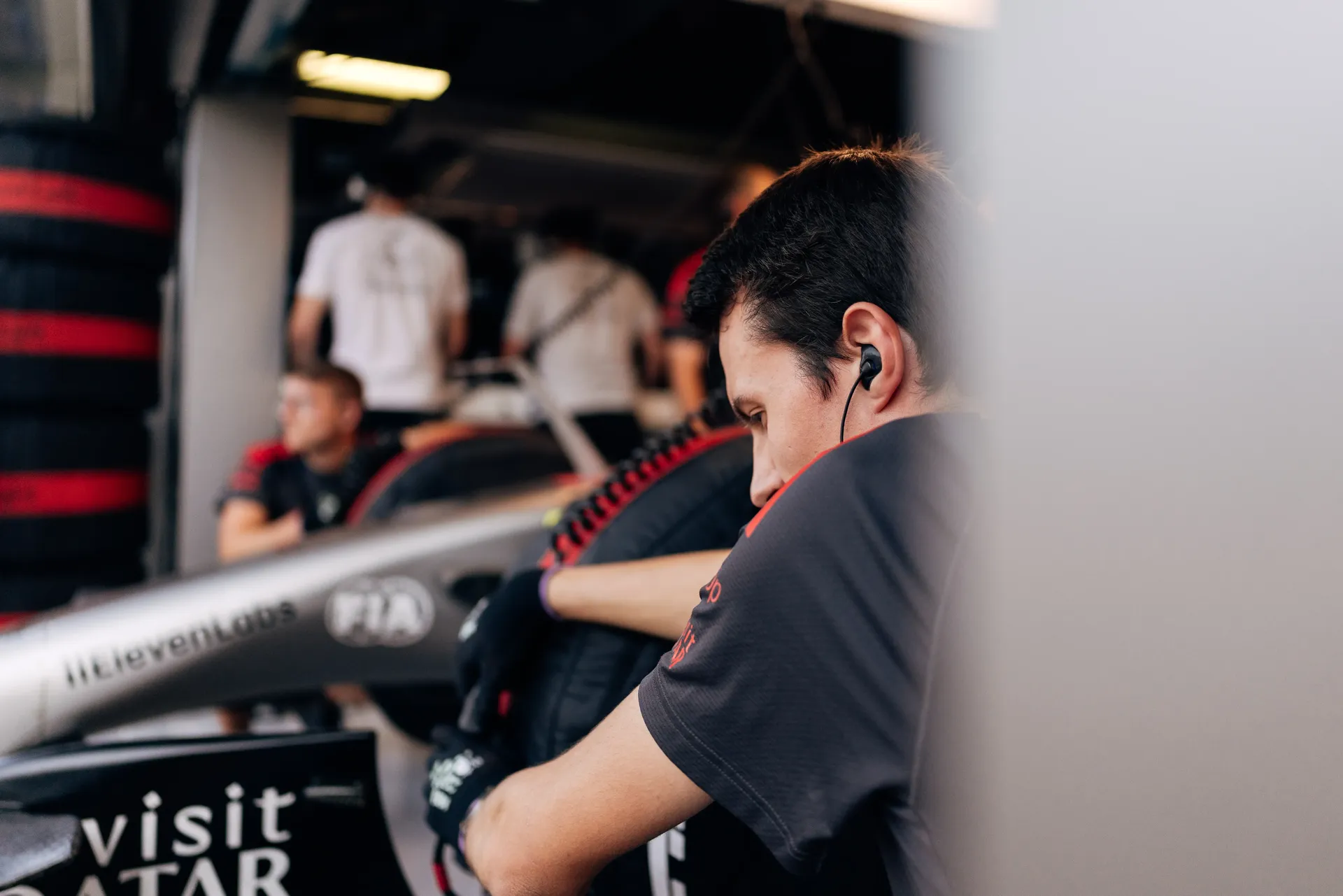 Audi Revolut F1® Team mechanic working on the Audi R26 team car inside the garage.