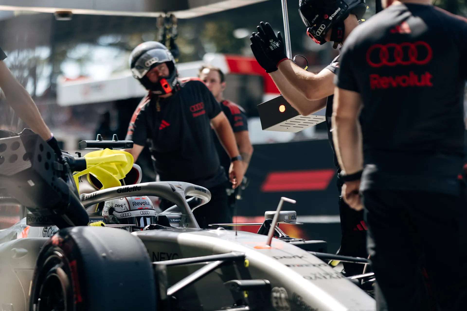 Audi Revolut F1® Team mechanics working around the Audi R26 car in the garage.