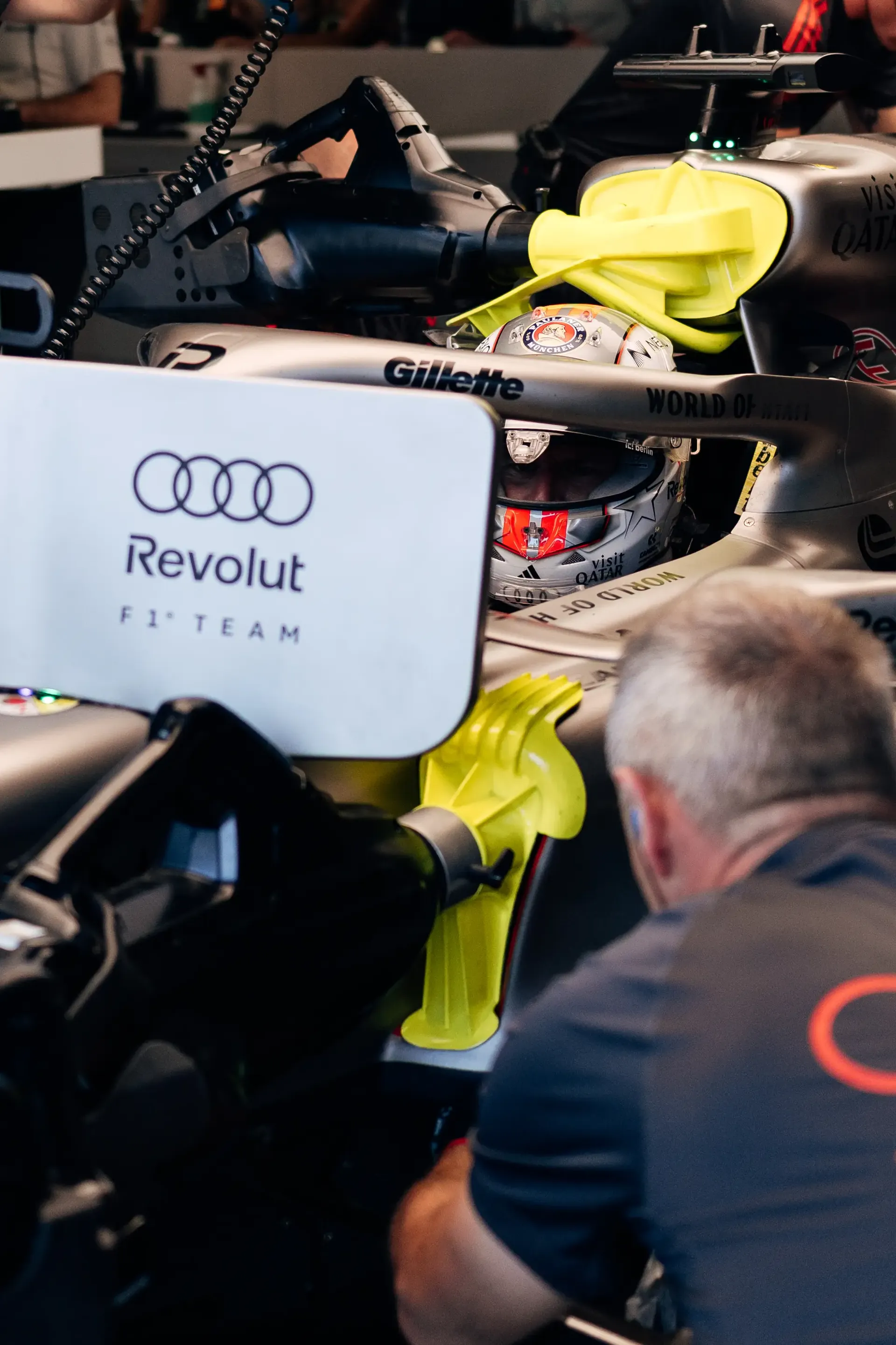 Audi Revolut F1® Team mechanics working around the Audi R26 in the garage.