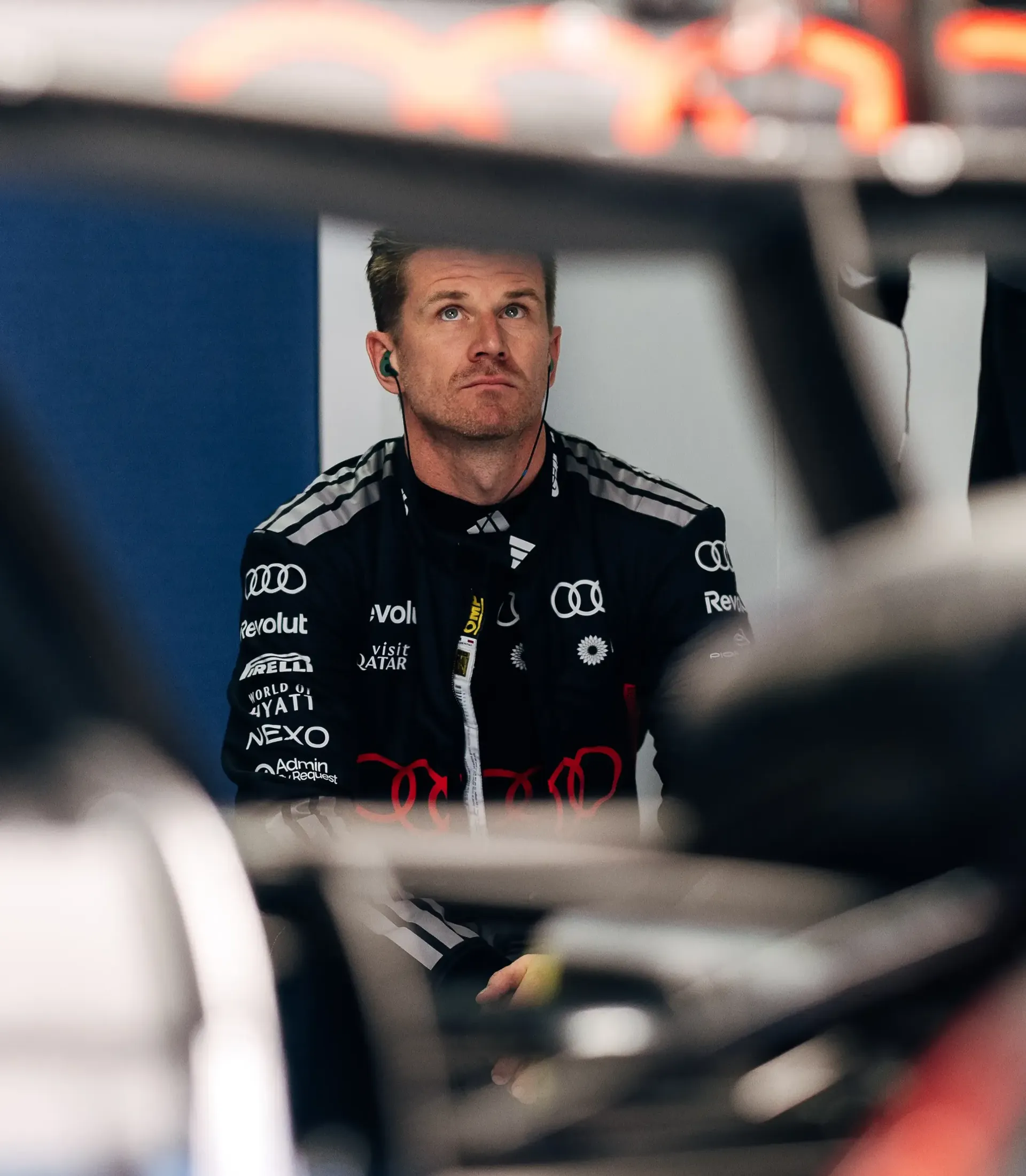 Audi Revolut F1® Team driver Nico Hulkenberg standing beside the Audi R26 car in the garage