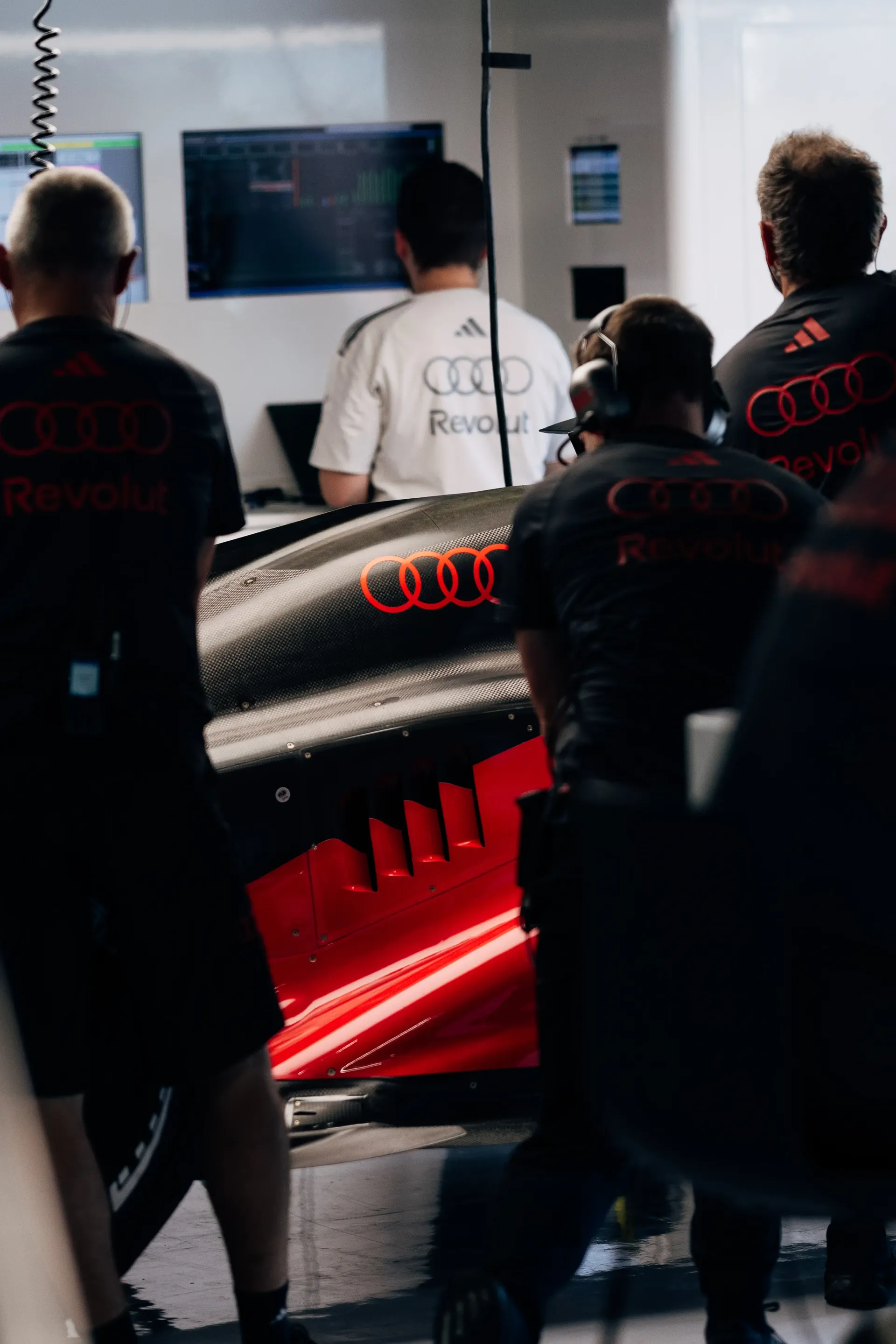 Audi Revolut F1® Team mechanics working around the car in the garage