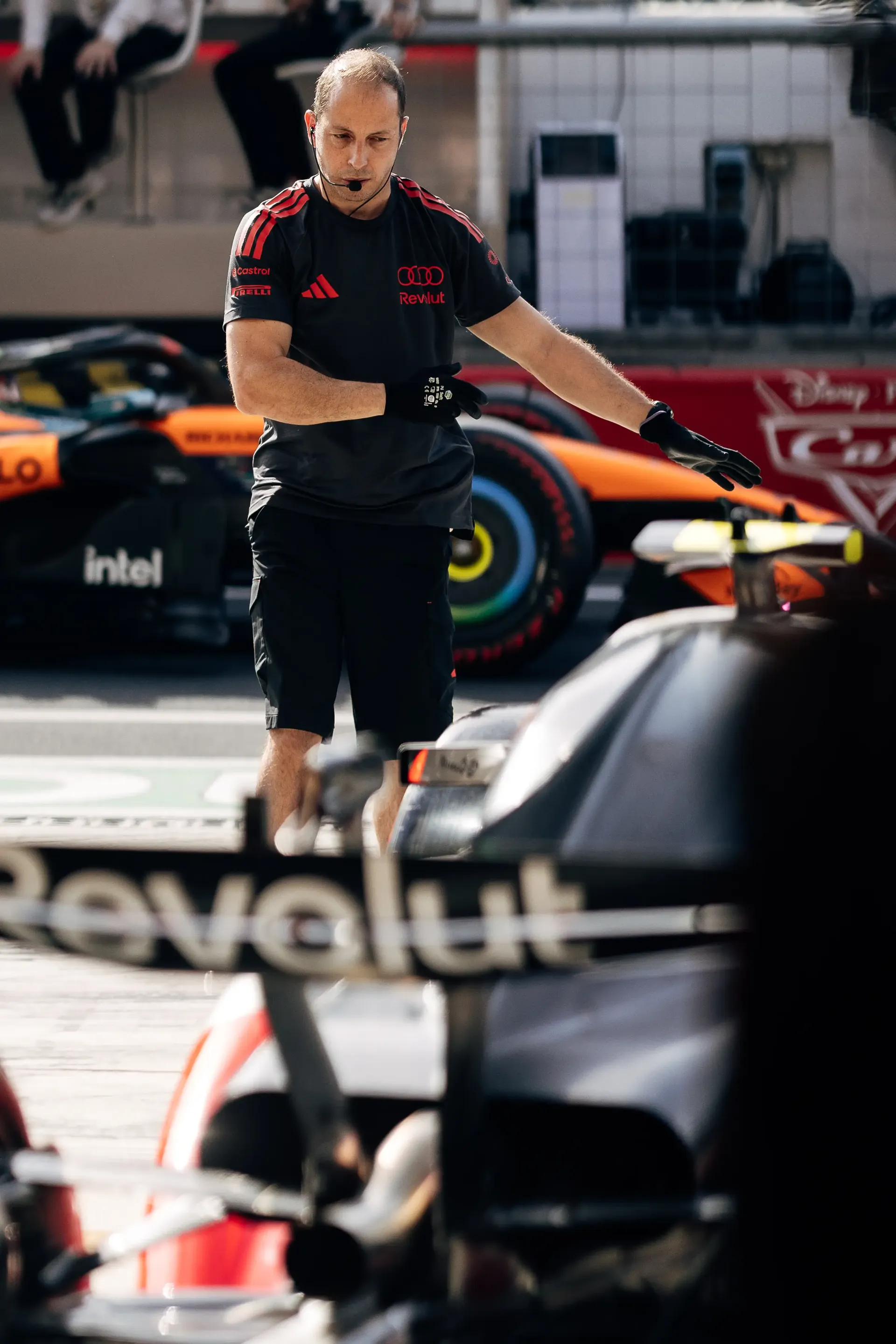 Audi Revolut F1® Team mechanic standing beside the car in the pit lane
