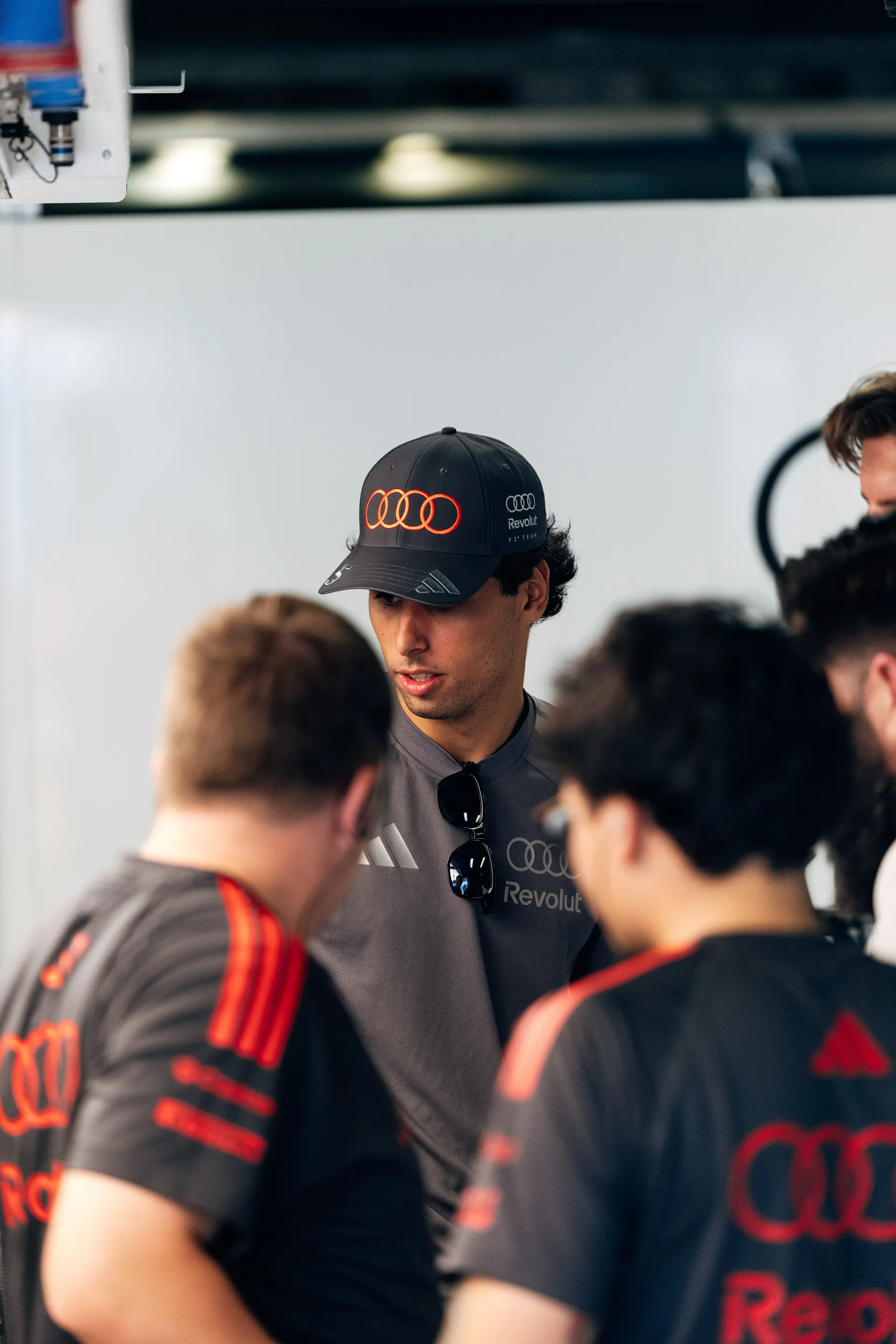 Gabriel Bortoleto speaking with Audi Revolut F1® Team mechanics inside the garage at the Italian Grand Prix.