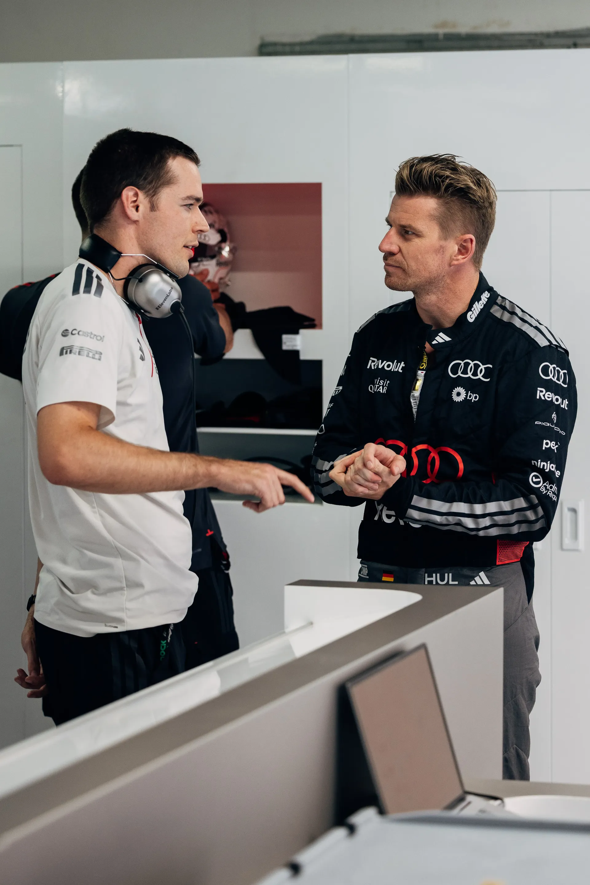 Nico Hulkenberg speaking with an Audi Revolut F1® Team mechanic in the paddock.