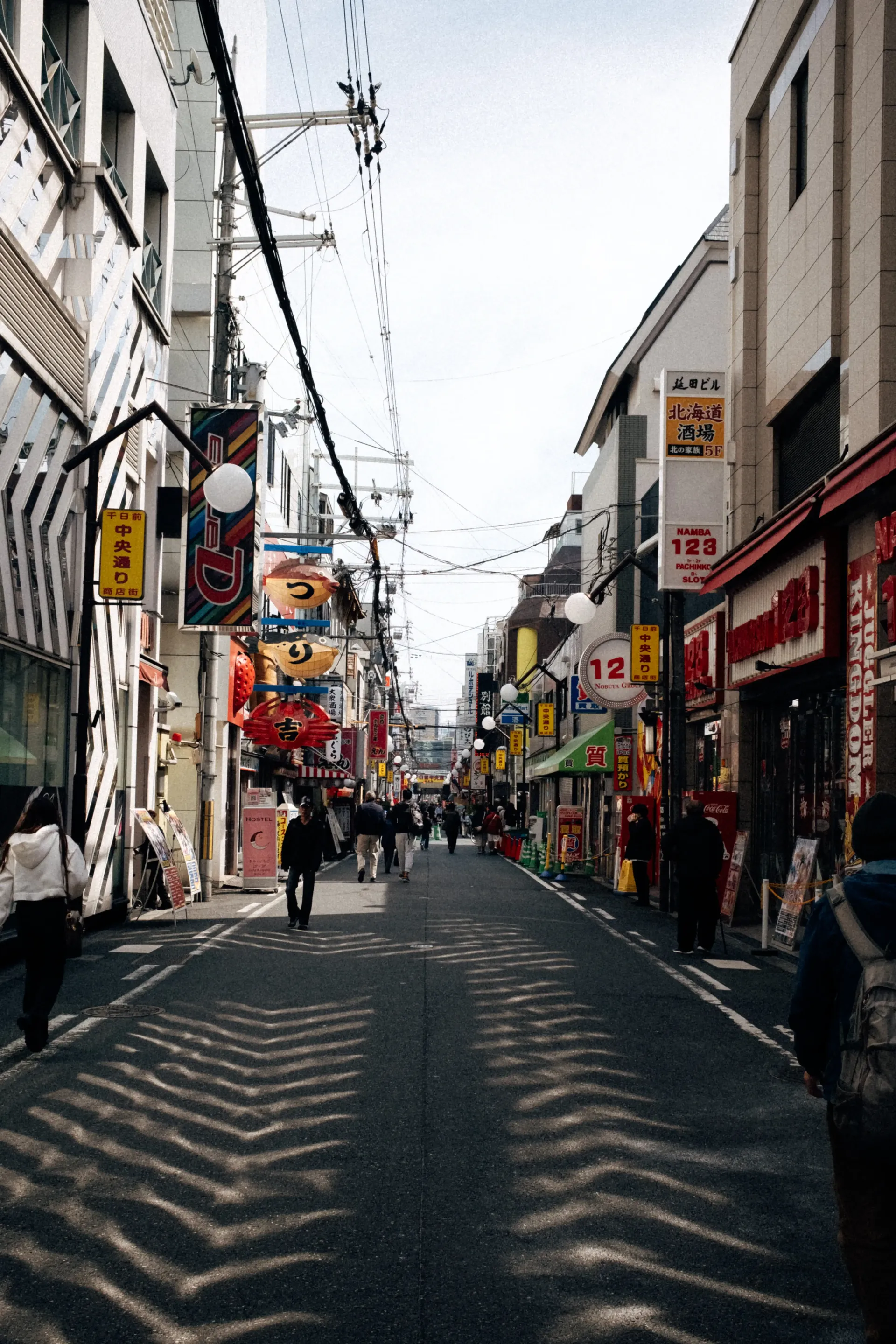 Empty narrow street in a Japanese city with shops and power lines, early morning atmosphere near Suzuka during race weekend.