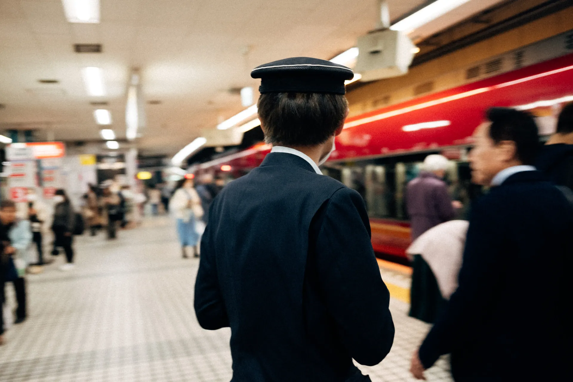Train station staff and passengers inside a busy Japanese station, travel to Suzuka for Formula 1 race.