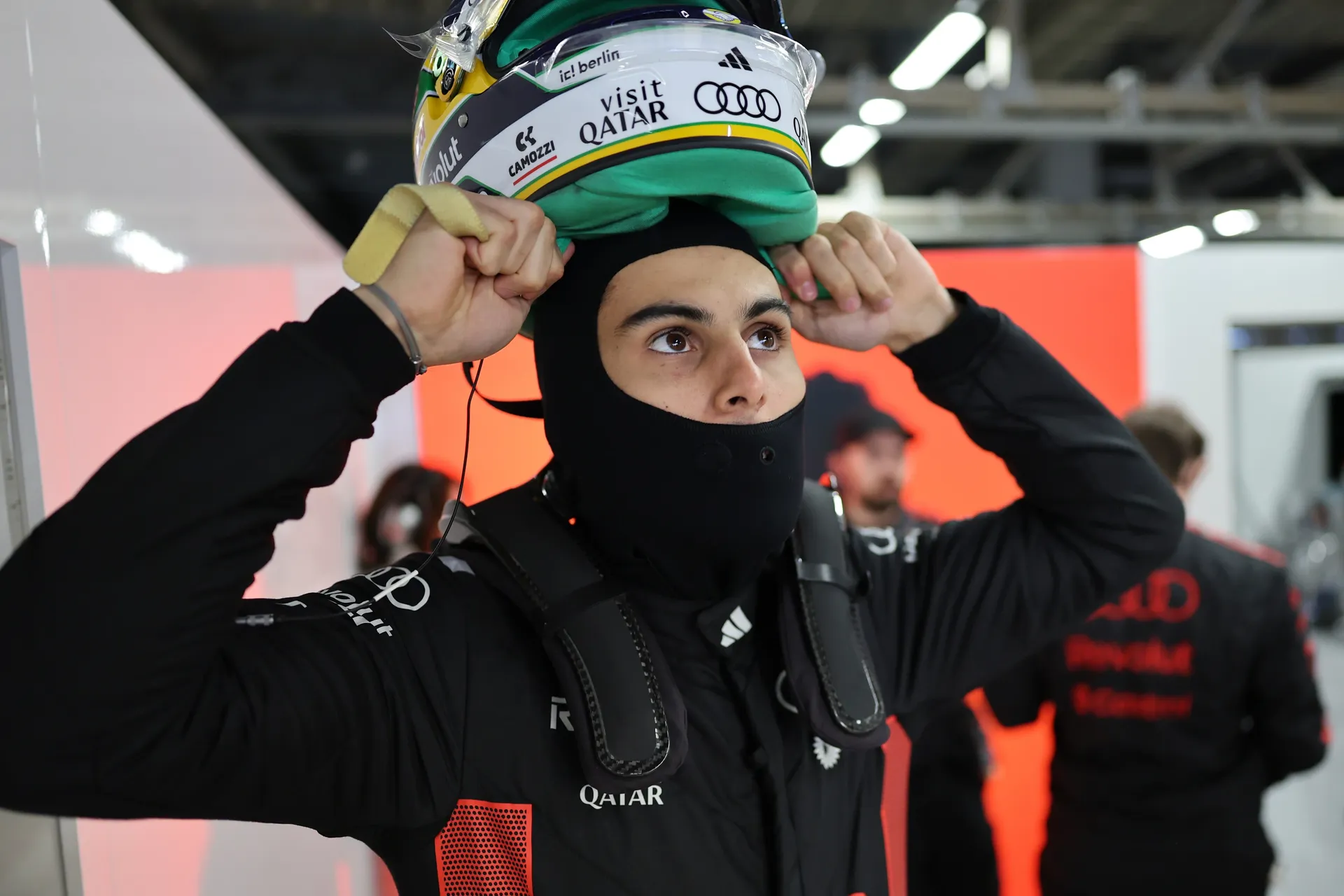 Gabriel Bortoleto adjusts his balaclava and lifts his Brazil themed helmet into position inside the Audi Revolut F1® Team garage before heading out.